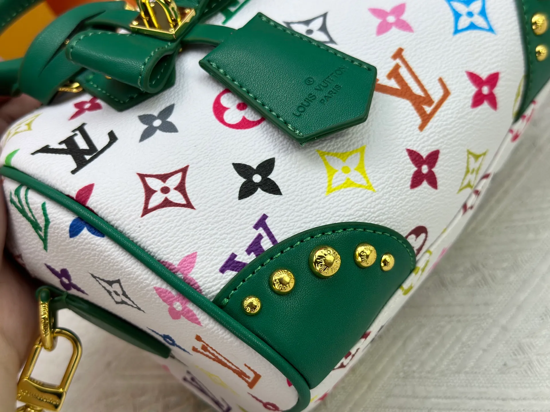 P260 upgraded original M58953 M46234 M46222 Speedy Bandoulière 20 handbag is made of soft coated canvas, and the full-length Monogram pattern is traced in colorful rainbow tones, highlighting the smart style of the Louis Vuitton x Murakami reissue series. The Toron handle and detachable shoulder strap are constructed of cow leather, the metal corners recall classic luggage elements, and the bow-shaped key bag and padlock add brand touches. Dimensions: 20.5 x 13.5 x 12.0 cm (length x height x width)