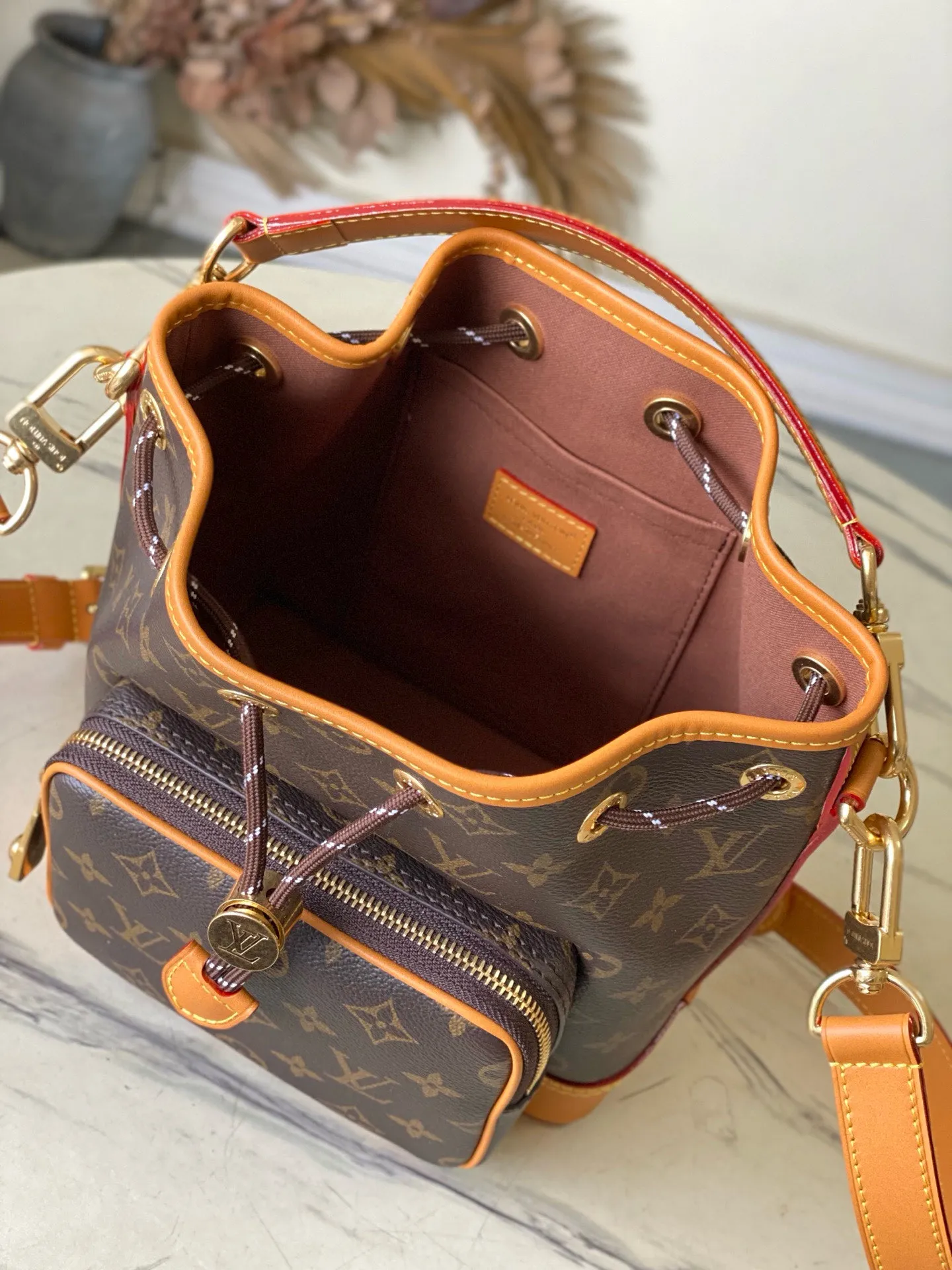 💰1200 Top original order M14017 Noe Cargo bucket bag is constructed of Monogram canvas and decorated with distressed leather trim. It inherits the Noe bucket bag designed in 1932 for carrying champagne bottles. The large front pockets and refined details nod to Louis Vuitton's rich history while meeting modern needs. The top handle and shoulder strap are detachable for flexible portability. Dimensions: 22 × 24 × 16 cm