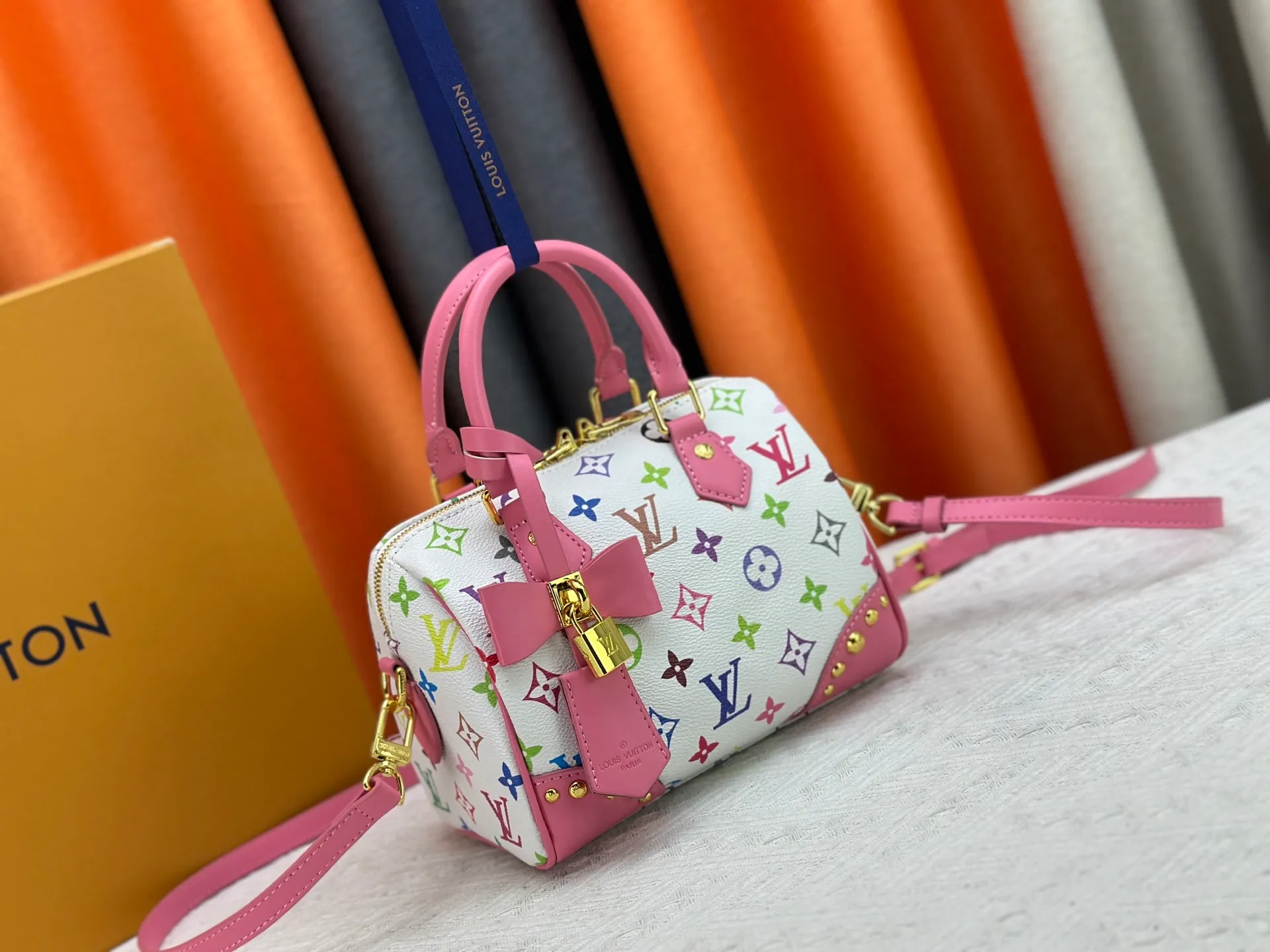 P260 upgraded original M58953 M46234 M46222 Speedy Bandoulière 20 handbag is made of soft coated canvas, and the full-length Monogram pattern is traced in colorful rainbow tones, highlighting the smart style of the Louis Vuitton x Murakami reissue series. The Toron handle and detachable shoulder strap are constructed of cow leather, the metal corners recall classic luggage elements, and the bow-shaped key bag and padlock add brand touches. Dimensions: 20.5 x 13.5 x 12.0 cm (length x height x width)