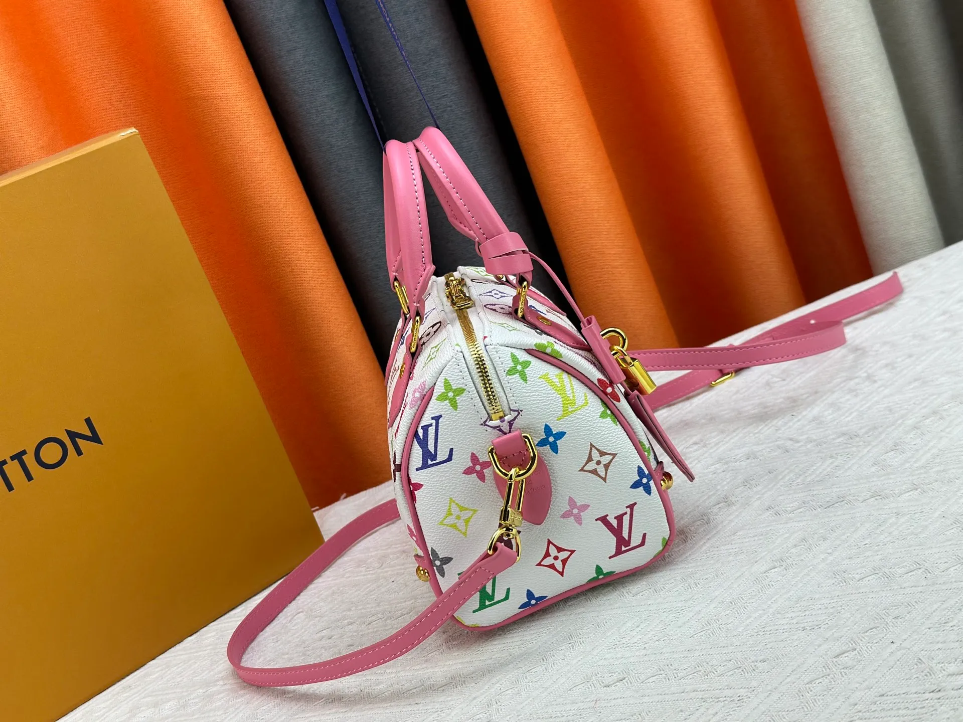 P260 upgraded original M58953 M46234 M46222 Speedy Bandoulière 20 handbag is made of soft coated canvas, and the full-length Monogram pattern is traced in colorful rainbow tones, highlighting the smart style of the Louis Vuitton x Murakami reissue series. The Toron handle and detachable shoulder strap are constructed of cow leather, the metal corners recall classic luggage elements, and the bow-shaped key bag and padlock add brand touches. Dimensions: 20.5 x 13.5 x 12.0 cm (length x height x width)