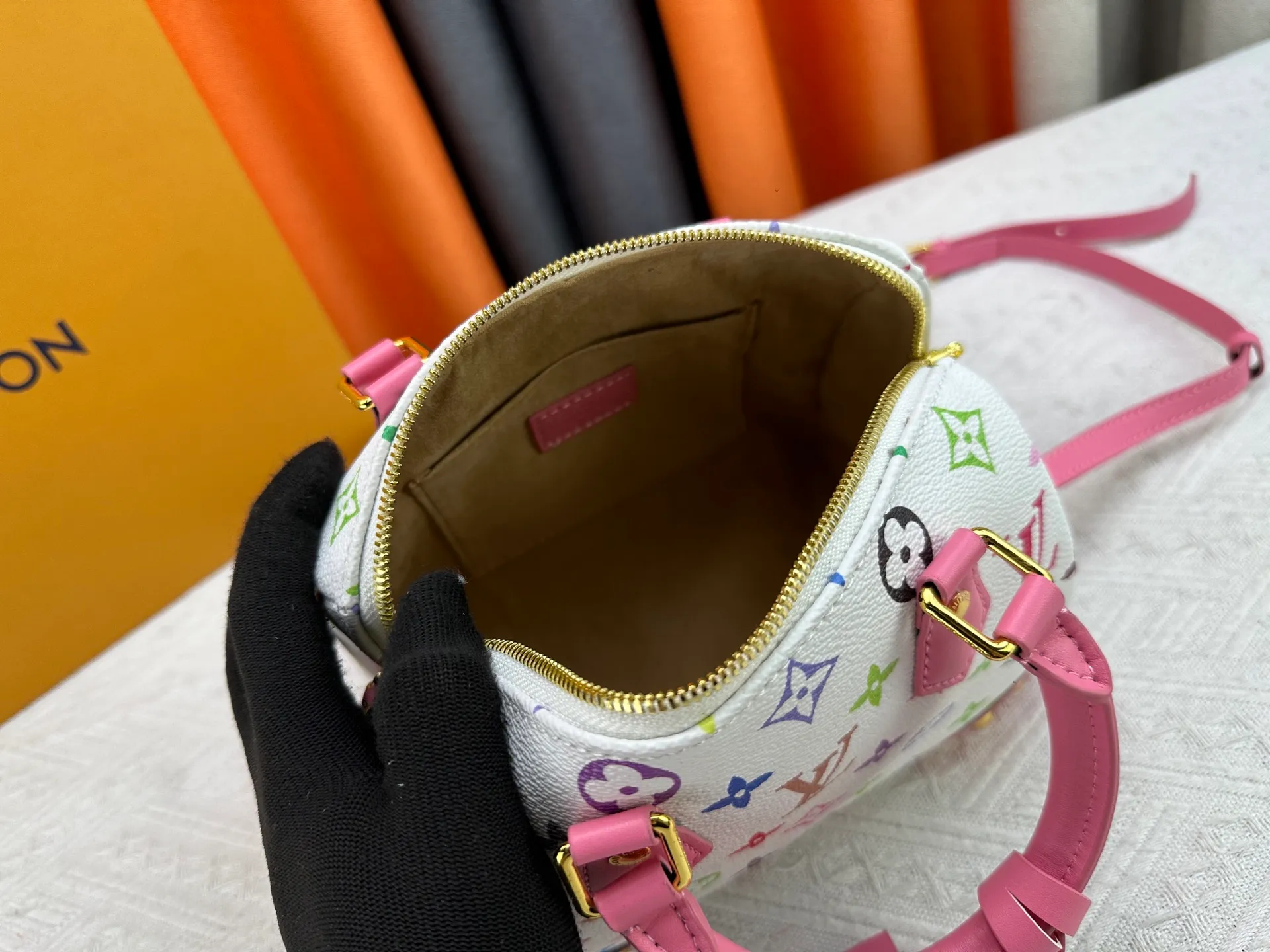 P260 upgraded original M58953 M46234 M46222 Speedy Bandoulière 20 handbag is made of soft coated canvas, and the full-length Monogram pattern is traced in colorful rainbow tones, highlighting the smart style of the Louis Vuitton x Murakami reissue series. The Toron handle and detachable shoulder strap are constructed of cow leather, the metal corners recall classic luggage elements, and the bow-shaped key bag and padlock add brand touches. Dimensions: 20.5 x 13.5 x 12.0 cm (length x height x width)