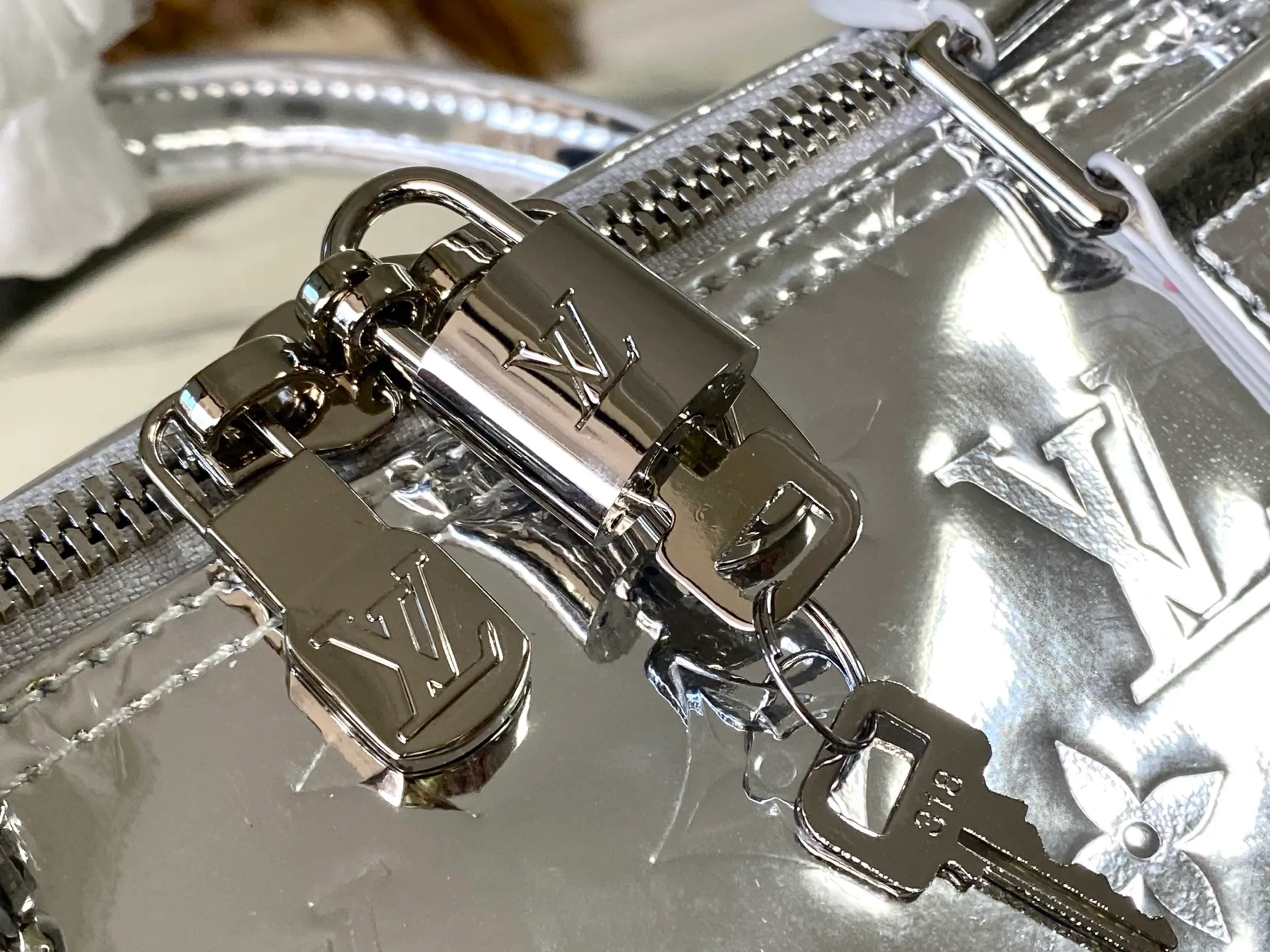 💰1560 (top layer leather) top original order M26766 silver This Keepall Bandouliere 45 travel bag uses Monogram Miroir canvas to convey a futuristic style, and then uses a mirror effect coating to upgrade its wear resistance. The hidden zipper pocket inside the mesh ensures safe storage of various items, and the top handle and detachable and adjustable shoulder strap allow for flexible carrying. Dimensions: 45 × 27 × 20 cm