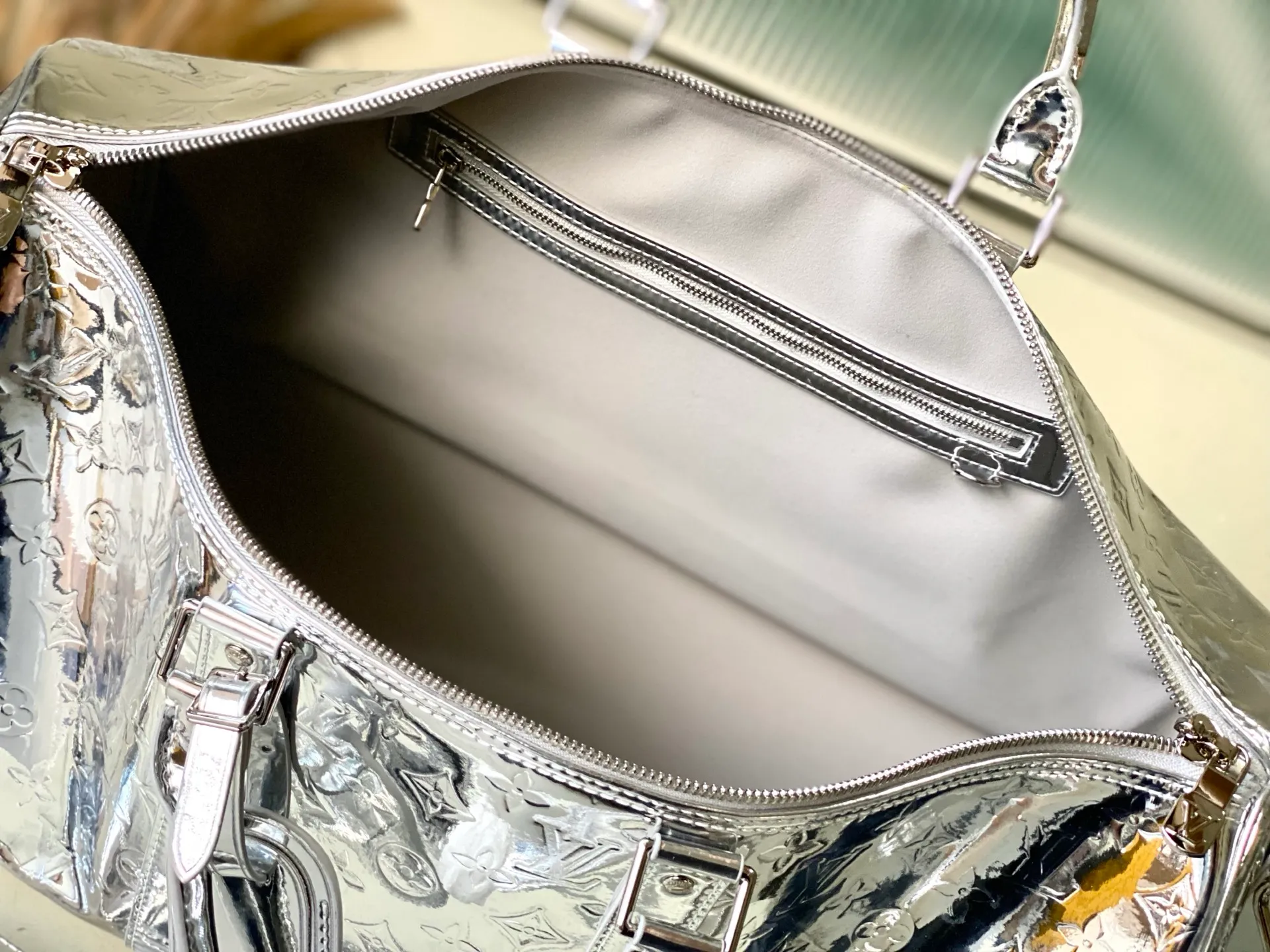 💰1560 (top layer leather) top original order M26766 silver This Keepall Bandouliere 45 travel bag uses Monogram Miroir canvas to convey a futuristic style, and then uses a mirror effect coating to upgrade its wear resistance. The hidden zipper pocket inside the mesh ensures safe storage of various items, and the top handle and detachable and adjustable shoulder strap allow for flexible carrying. Dimensions: 45 × 27 × 20 cm