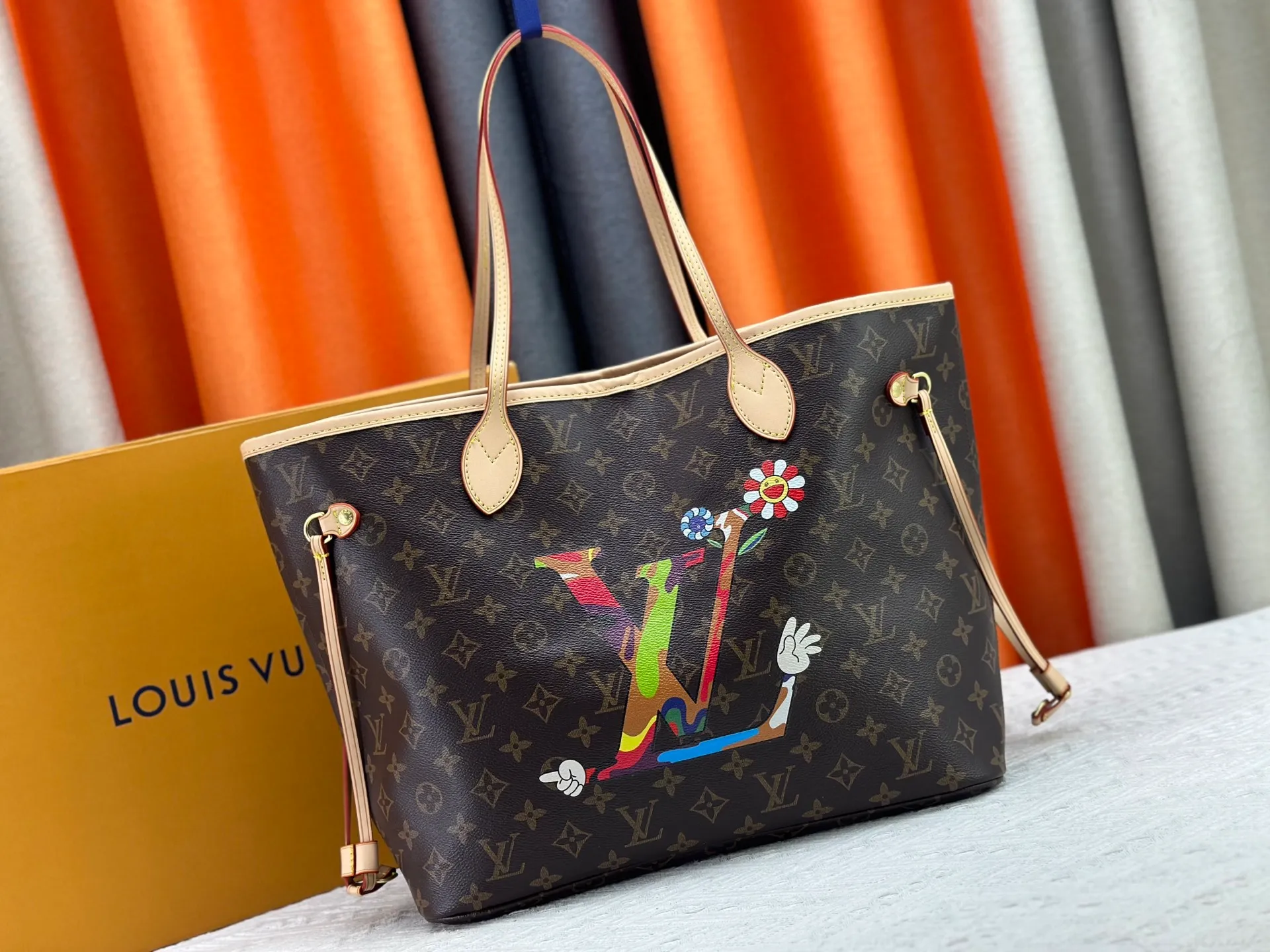 P260 Upgraded original M13675 M13271 M40995 This medium-sized Neverfull handbag is from the Louis Vuitton x Takashi Murakami reissue series. It uses Monogram canvas to create a spacious configuration, and then uses the smart Monogram floral pattern to interpret the artist's "ultra-flat" aesthetic style. Cowhide leather outlines the upper edge, handles and side straps, while the fabric lining incorporates colorful stripes. An interior zip pocket and a removable storage bag complete the functional design. Dimensions: 31.0 x 28.0 x 14.0 cm (length x height x width)