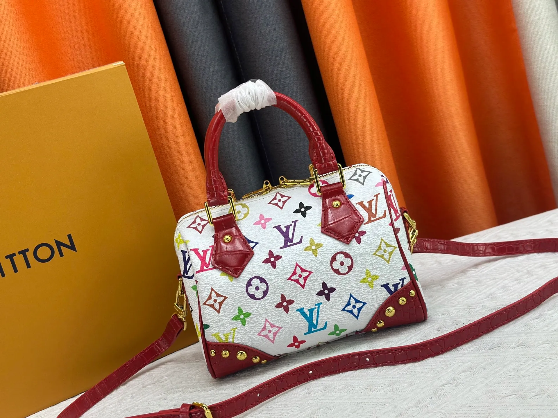 P260 Upgraded original crocodile pattern M13365 M58953 M46234 M46222 Speedy Bandoulière 20 handbag is made of soft coated canvas, and the full-length Monogram pattern is traced in colorful rainbow tones, highlighting the smart style of the Louis Vuitton x Murakami reissue series. The Toron handle and detachable shoulder strap are constructed of cow leather, the metal corners recall classic luggage elements, and the bow-shaped key bag and padlock add brand touches. Dimensions: 20.5 x 13.5 x 12.0 cm (length x height x width)
