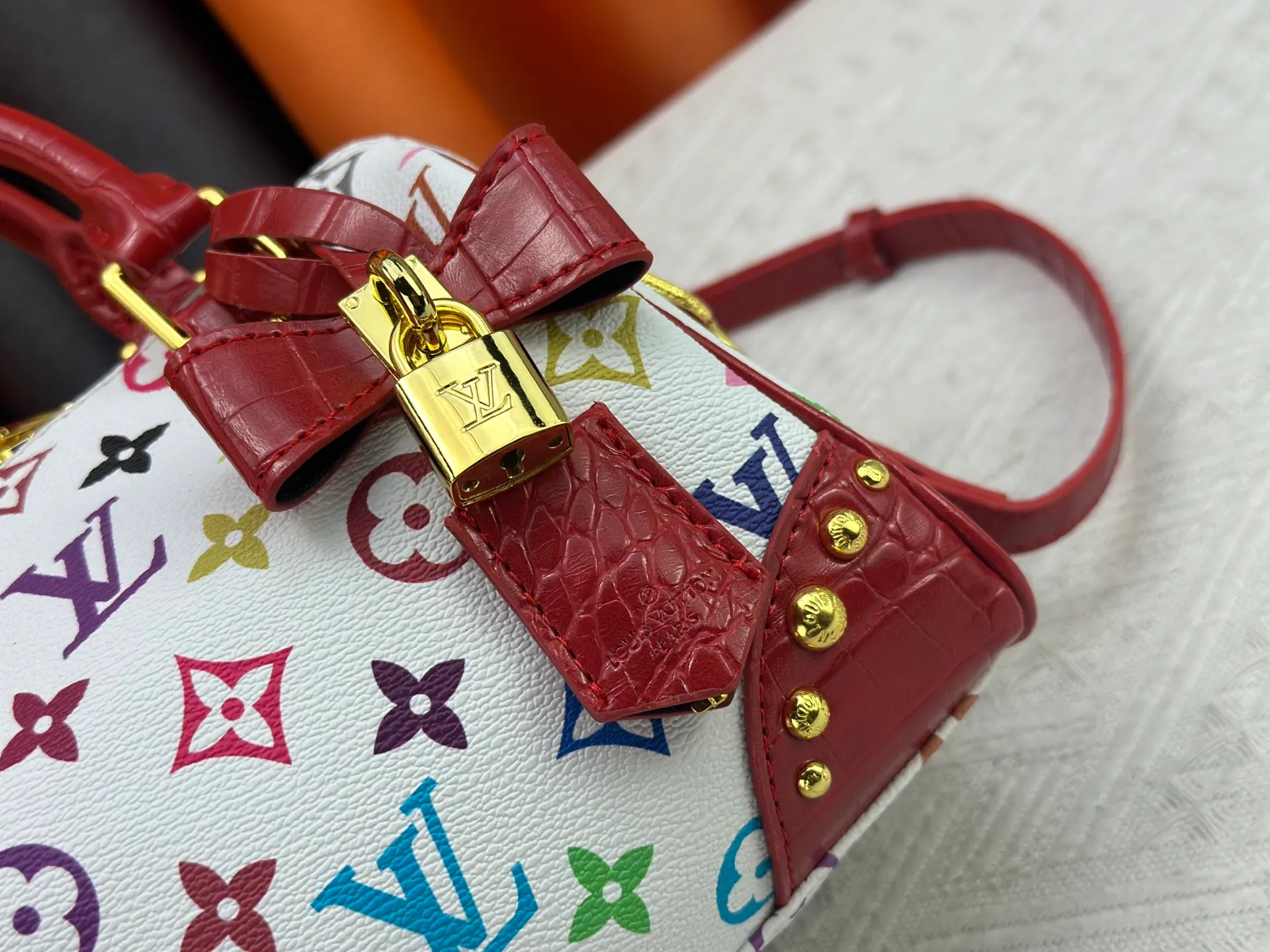 P260 Upgraded original crocodile pattern M13365 M58953 M46234 M46222 Speedy Bandoulière 20 handbag is made of soft coated canvas, and the full-length Monogram pattern is traced in colorful rainbow tones, highlighting the smart style of the Louis Vuitton x Murakami reissue series. The Toron handle and detachable shoulder strap are constructed of cow leather, the metal corners recall classic luggage elements, and the bow-shaped key bag and padlock add brand touches. Dimensions: 20.5 x 13.5 x 12.0 cm (length x height x width)