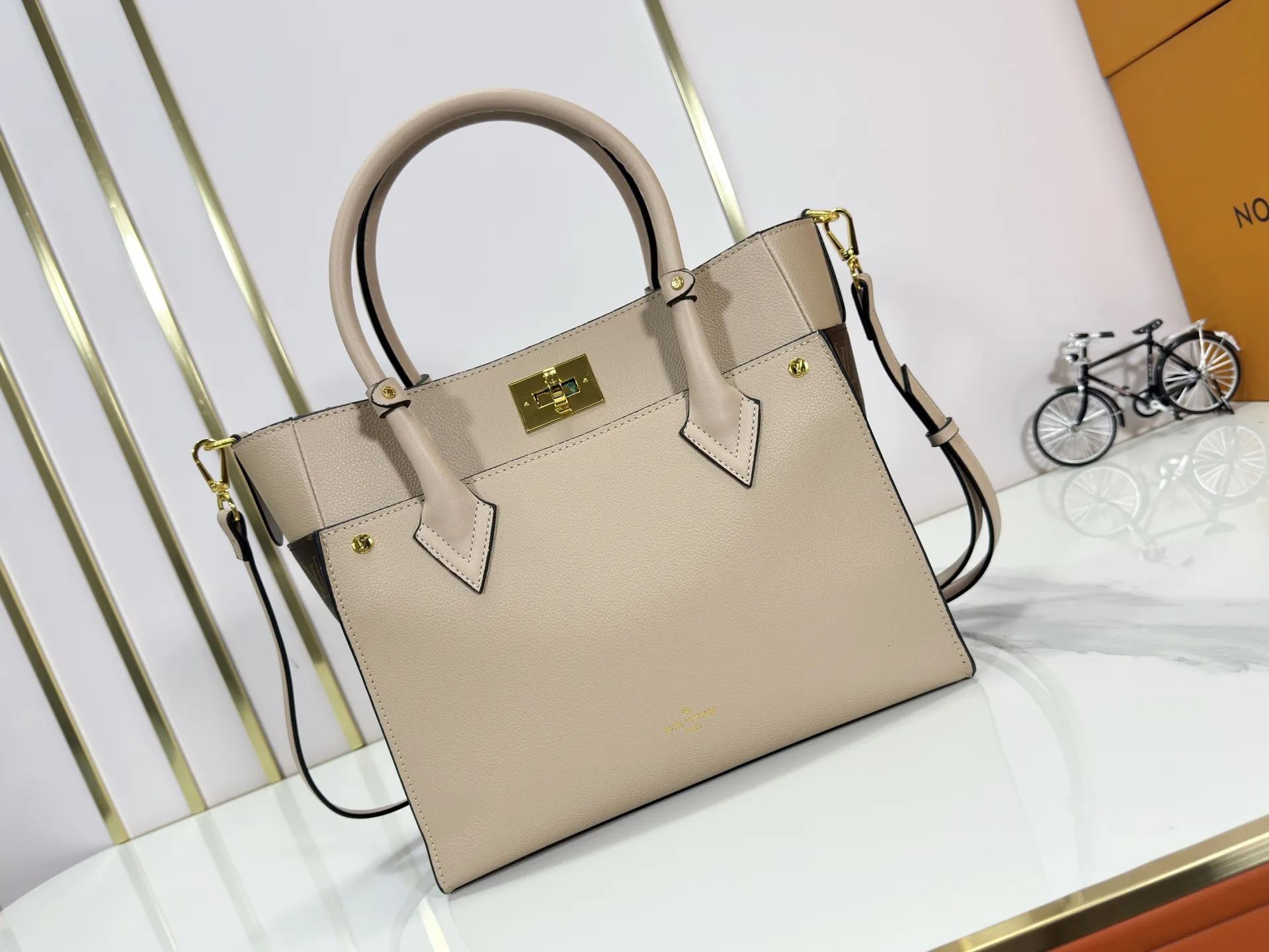 P340 upgraded original M53826 M53825 M53824 M53823On My Side handbag shows the elegant fusion of calfskin and classic Monogram canvas. Contrasting canvas shapes the large outer pocket, creating a trompe l'oeil effect as if two handbags merge into one. Plenty of space can easily accommodate office needs, and the adjustable shoulder strap allows for a cross-body style. Dimensions: 30.5 x 24.5 x 14 cm (Length x Height x Width) - Calfskin and Monogram coated canvas - Cowhide leather trim - Microfiber lining - 2 top handles for hand or elbow carry - Adjustable shoulder strap for shoulder or cross-body wear - Lock closure - 2 outer pockets with magnetic closure - Zip pocket - 1 patch pocket