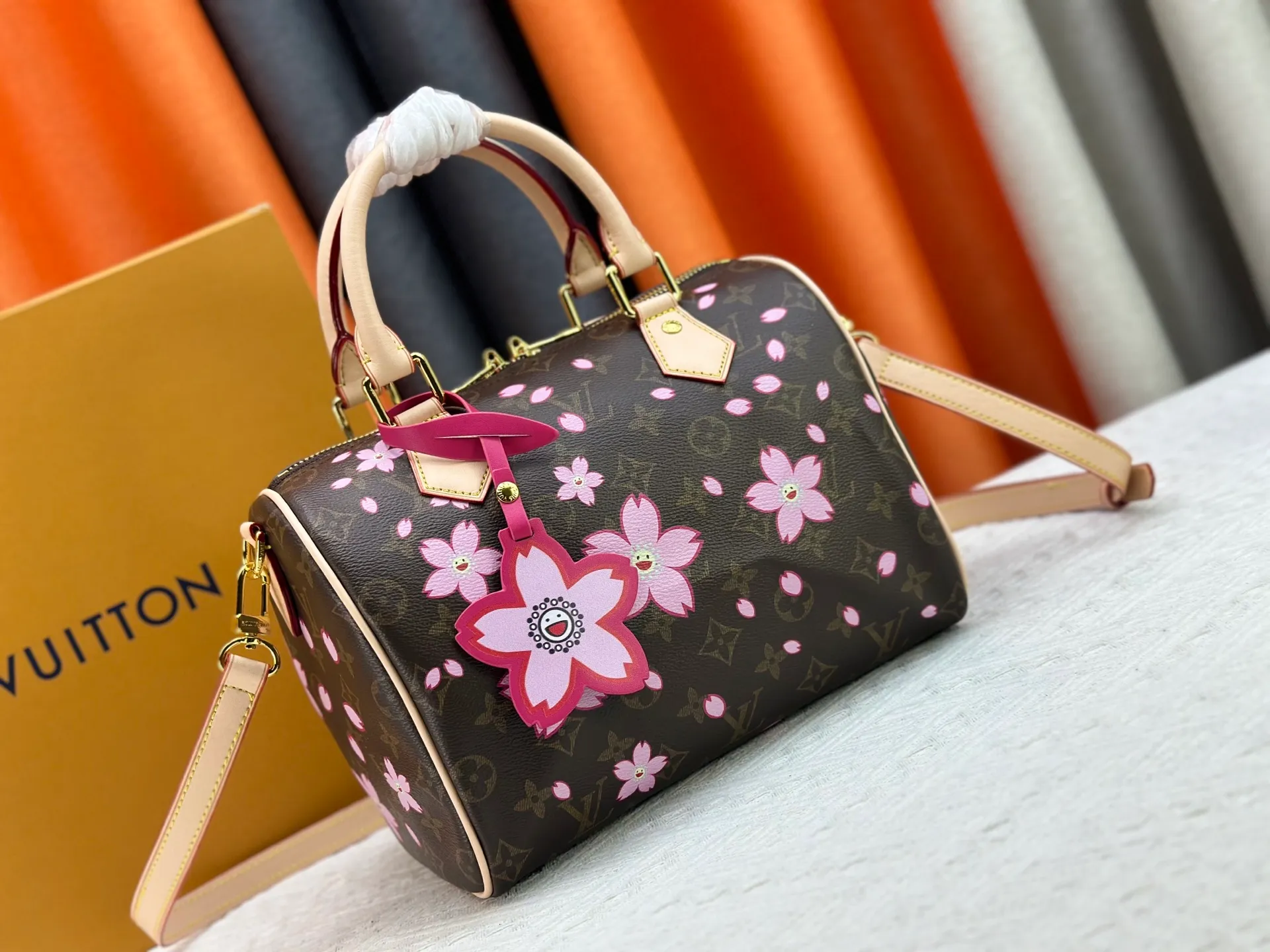 P260 M14174 This Speedy Bandoulière 25 handbag is from the Louis Vuitton x Takashi Murakami replica series. It incorporates the brand's classic Monogram coating into Takashi Murakami's vivid Cherry Blossom pattern, and then continues the same element into the removable bag decoration. Cow leather constructed Toron handles and removable leather shoulder strap, dual zippers and padlock keep personal belongings safe and secure.  19 x 15 x 25 cm (H x W x L) Cherry Blossom Monogram coated canvas Cow leather trim Removable Cherry Blossom trim Textile lining Metal hardware Double zip closure Internal zip pocket Padlock Holds a 6.7" smartphone, Victorine short wallet, headphones and keys Shoulder strap: removable, not adjustable Half-length strap: 44.0 cm Handles: Double handles