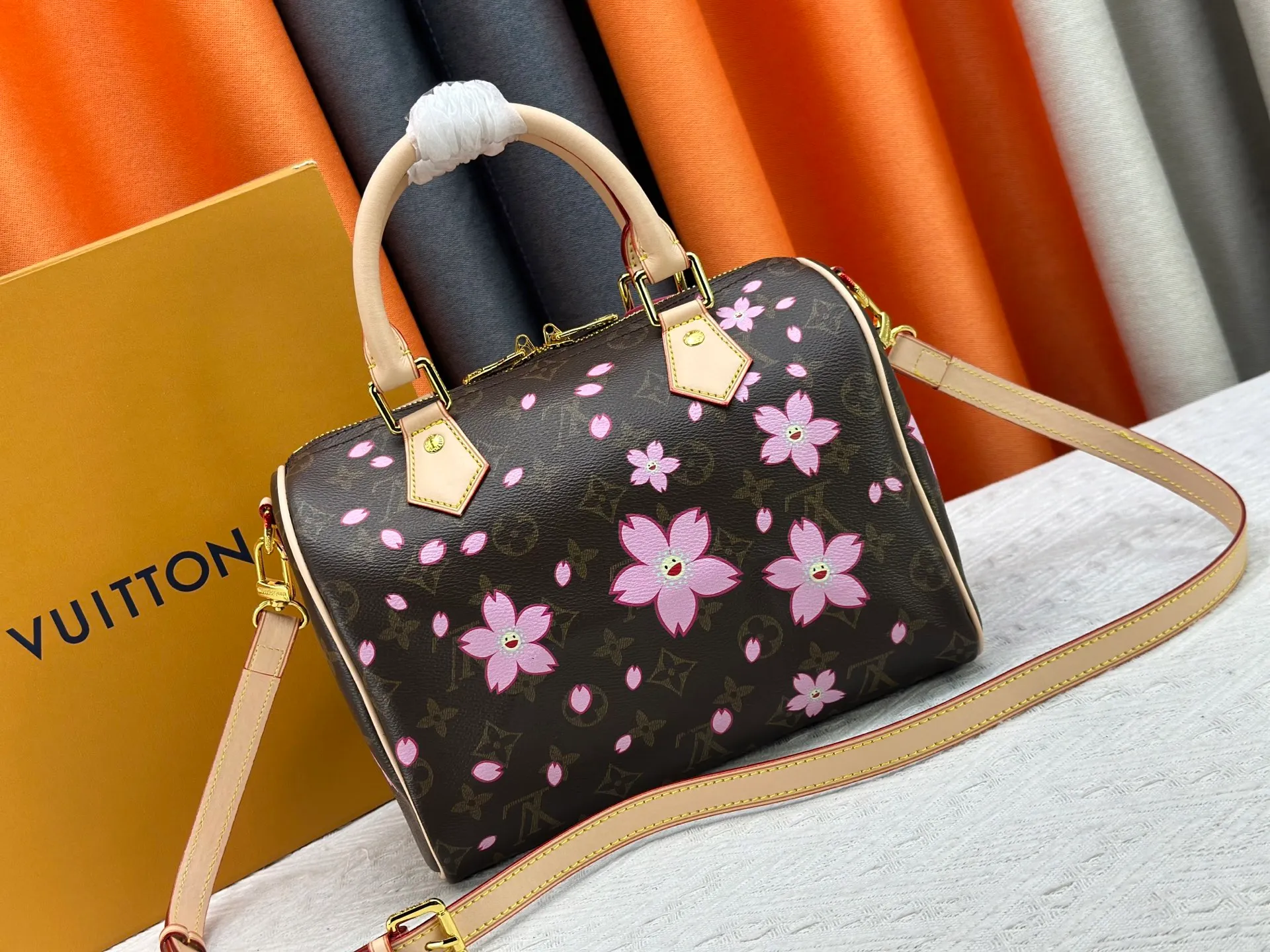 P260 M14174 This Speedy Bandoulière 25 handbag is from the Louis Vuitton x Takashi Murakami replica series. It incorporates the brand's classic Monogram coating into Takashi Murakami's vivid Cherry Blossom pattern, and then continues the same element into the removable bag decoration. Cow leather constructed Toron handles and removable leather shoulder strap, dual zippers and padlock keep personal belongings safe and secure.  19 x 15 x 25 cm (H x W x L) Cherry Blossom Monogram coated canvas Cow leather trim Removable Cherry Blossom trim Textile lining Metal hardware Double zip closure Internal zip pocket Padlock Holds a 6.7" smartphone, Victorine short wallet, headphones and keys Shoulder strap: removable, not adjustable Half-length strap: 44.0 cm Handles: Double handles