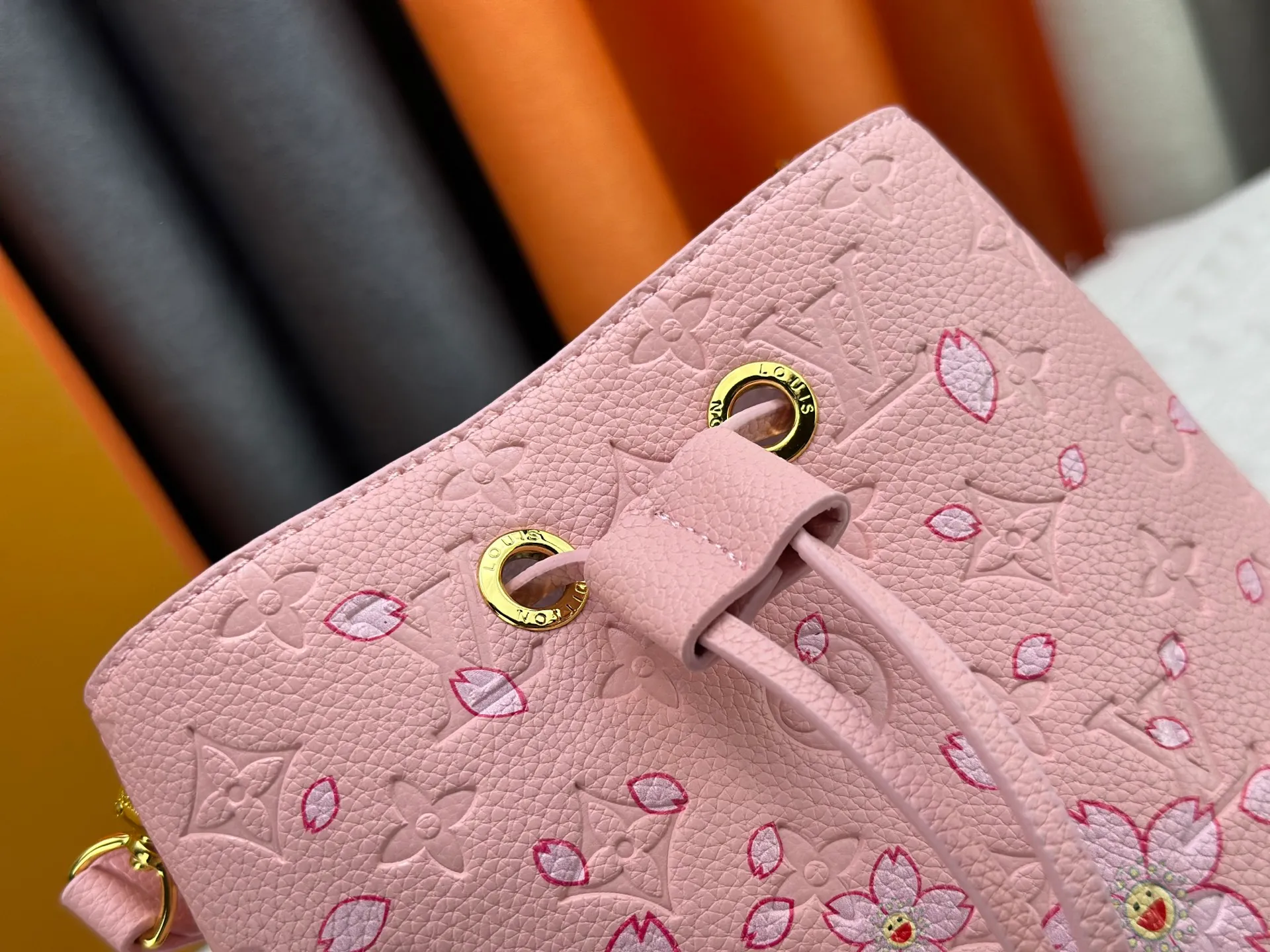 P240 M13676 M44021 This NeoNoe BB bucket bag comes from the Louis Vuitton × Murakami replica series, using Monogram Empreinte leather to convey a fresh breath and smart style. Murakami's signature Cherry Blossom pattern appears on the Monogram embossed surface, and the same floral element is transformed into a slide buckle to tighten the drawstring. Size: 20x20x13cm