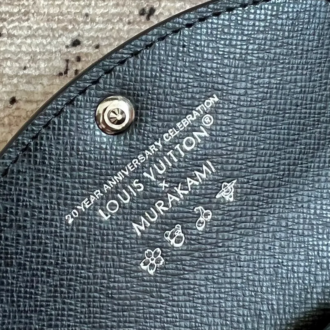 Factory price 300 Top original order M13399 black color This Rosalie coin purse is from the Louis Vuitton x Takashi Murakami reissue series. The Monogram coated canvas is dipped in vibrant colors, subtly paying tribute to the distinctive style of Japanese artist Takashi Murakami. The compact construction features a rounded flap and snap closure, and the interior houses a zipped coin pocket with Monogram pullers. 8 x 2.5 x 11 cm (height x width x length)