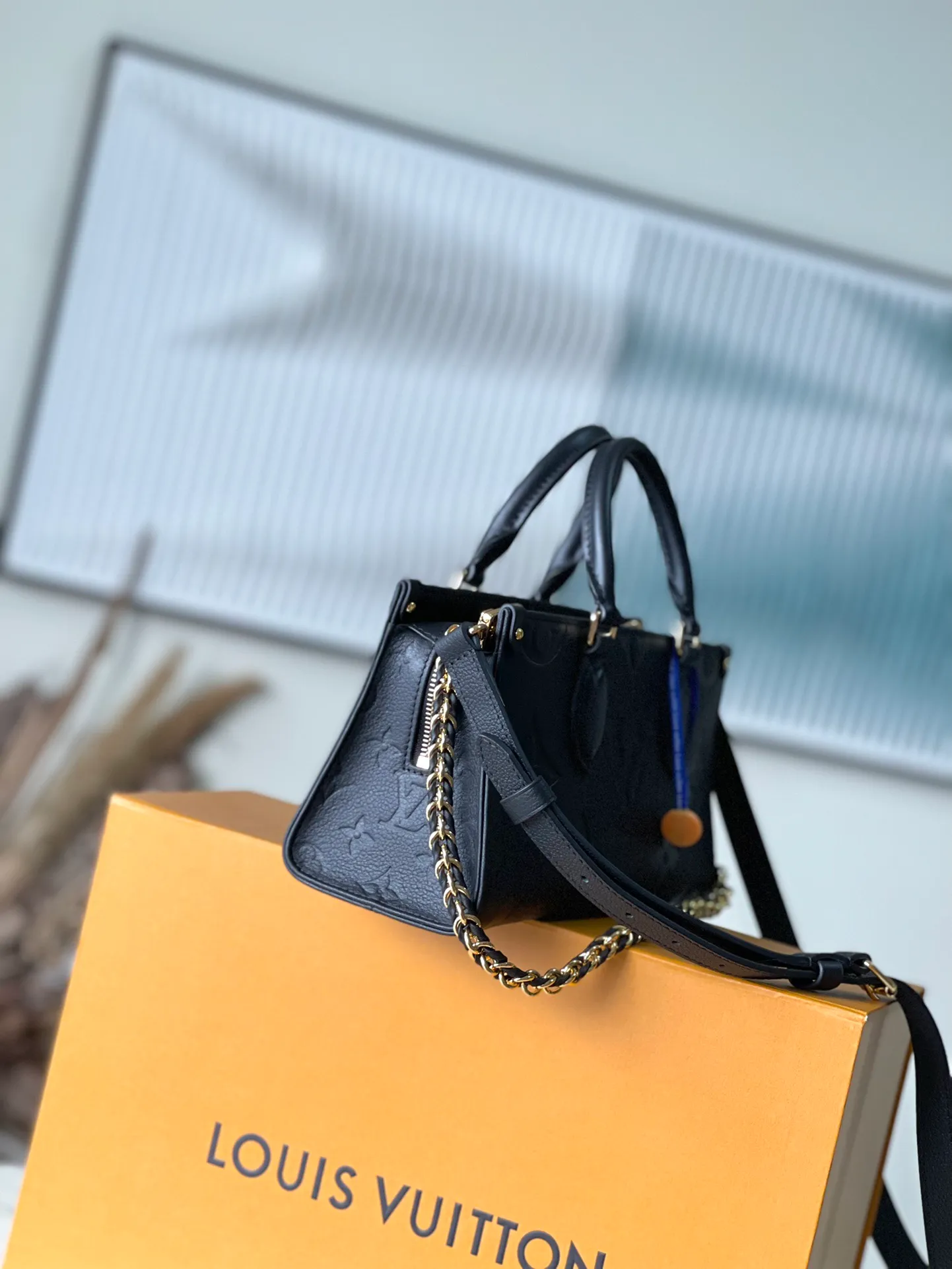 💰1060 (top-grain leather) top original M23640 black This OnTheGo East West handbag introduces the OnTheGo small tote bag design. It uses Monogram Empreinte leather to reinterpret East West's ample configuration. Giant Monogram is embossed on the leather body. The neat inner layer can store daily necessities. The top handle and detachable leather chain shoulder strap allow for multiple carrying methods. Size: 25x13x10cm