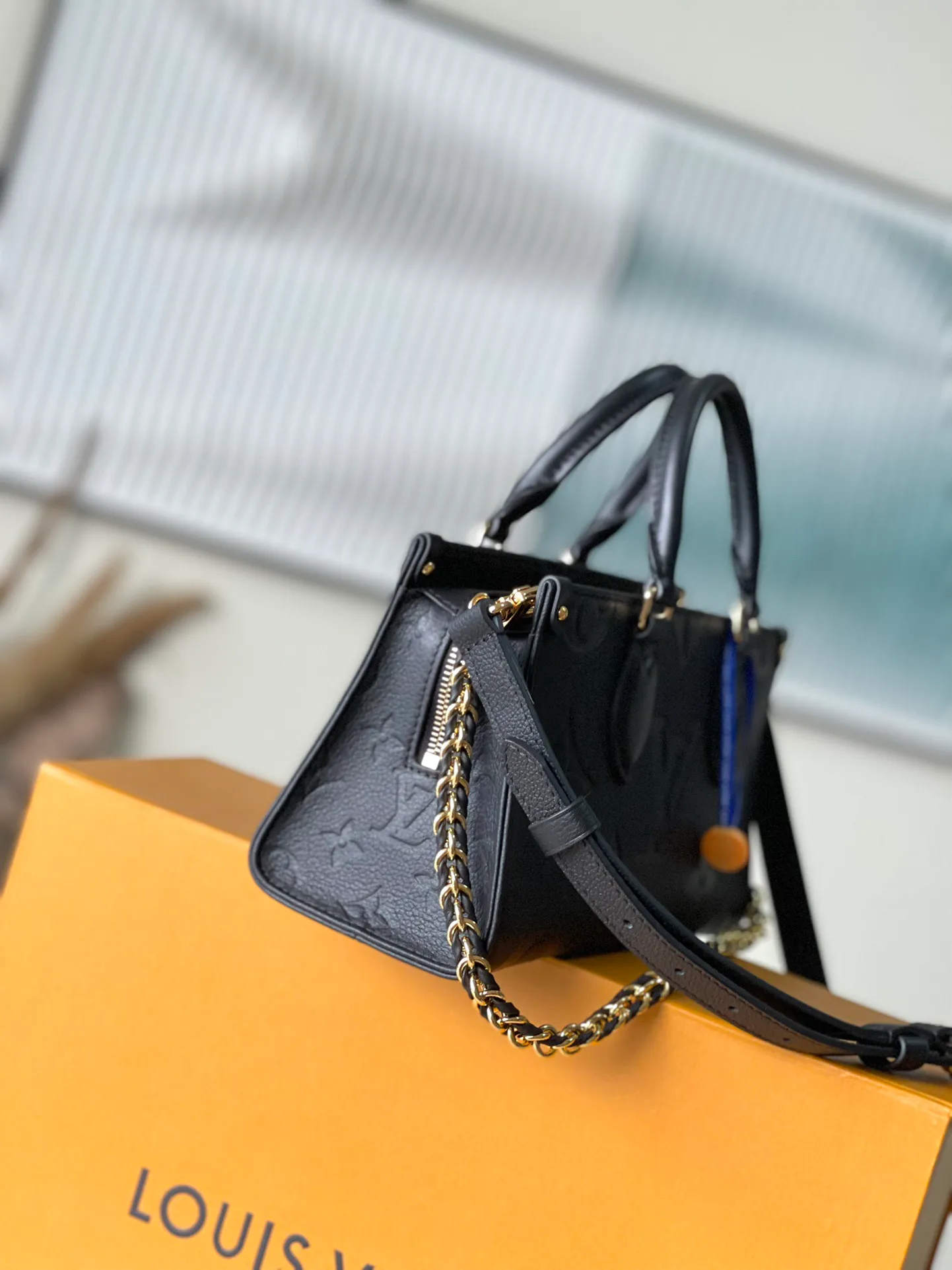 💰1060 (top-grain leather) top original M23640 black This OnTheGo East West handbag introduces the OnTheGo small tote bag design. It uses Monogram Empreinte leather to reinterpret East West's ample configuration. Giant Monogram is embossed on the leather body. The neat inner layer can store daily necessities. The top handle and detachable leather chain shoulder strap allow for multiple carrying methods. Size: 25x13x10cm
