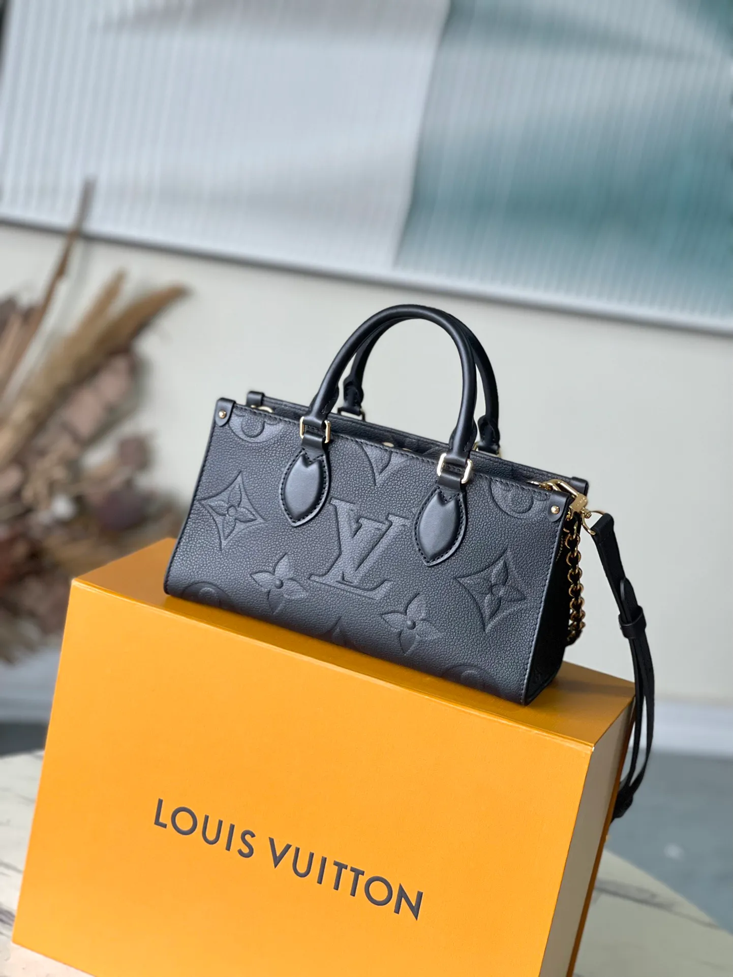 💰1060 (top-grain leather) top original M23640 black This OnTheGo East West handbag introduces the OnTheGo small tote bag design. It uses Monogram Empreinte leather to reinterpret East West's ample configuration. Giant Monogram is embossed on the leather body. The neat inner layer can store daily necessities. The top handle and detachable leather chain shoulder strap allow for multiple carrying methods. Size: 25x13x10cm
