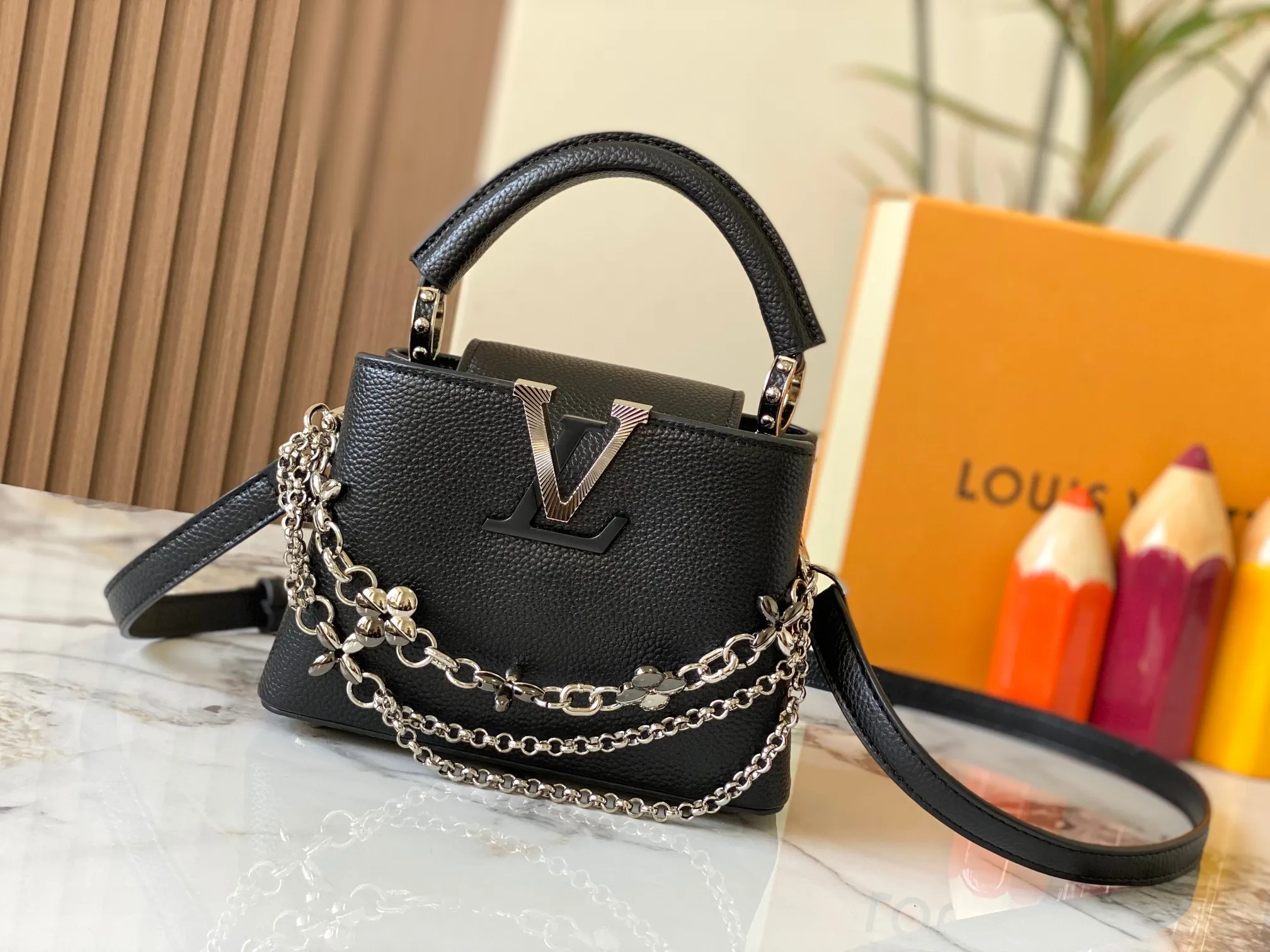 P480 [Guangzhou top quality original version] M26351 Black Silver This modern version of Capucines mini is made of timeless Taurillon leather and equipped with a jewelry-inspired Infinity chain. The bag is decorated with double galvanized metal parts, including the iconic Monogram floral pattern, and the LV Initials logo created with sunburst technology, creating a sundial-like light and shadow effect. The bag has multiple pockets and a detachable shoulder strap, allowing it to be carried on one shoulder or across the body. 14 x 8 x 21 cm (height x width x length)