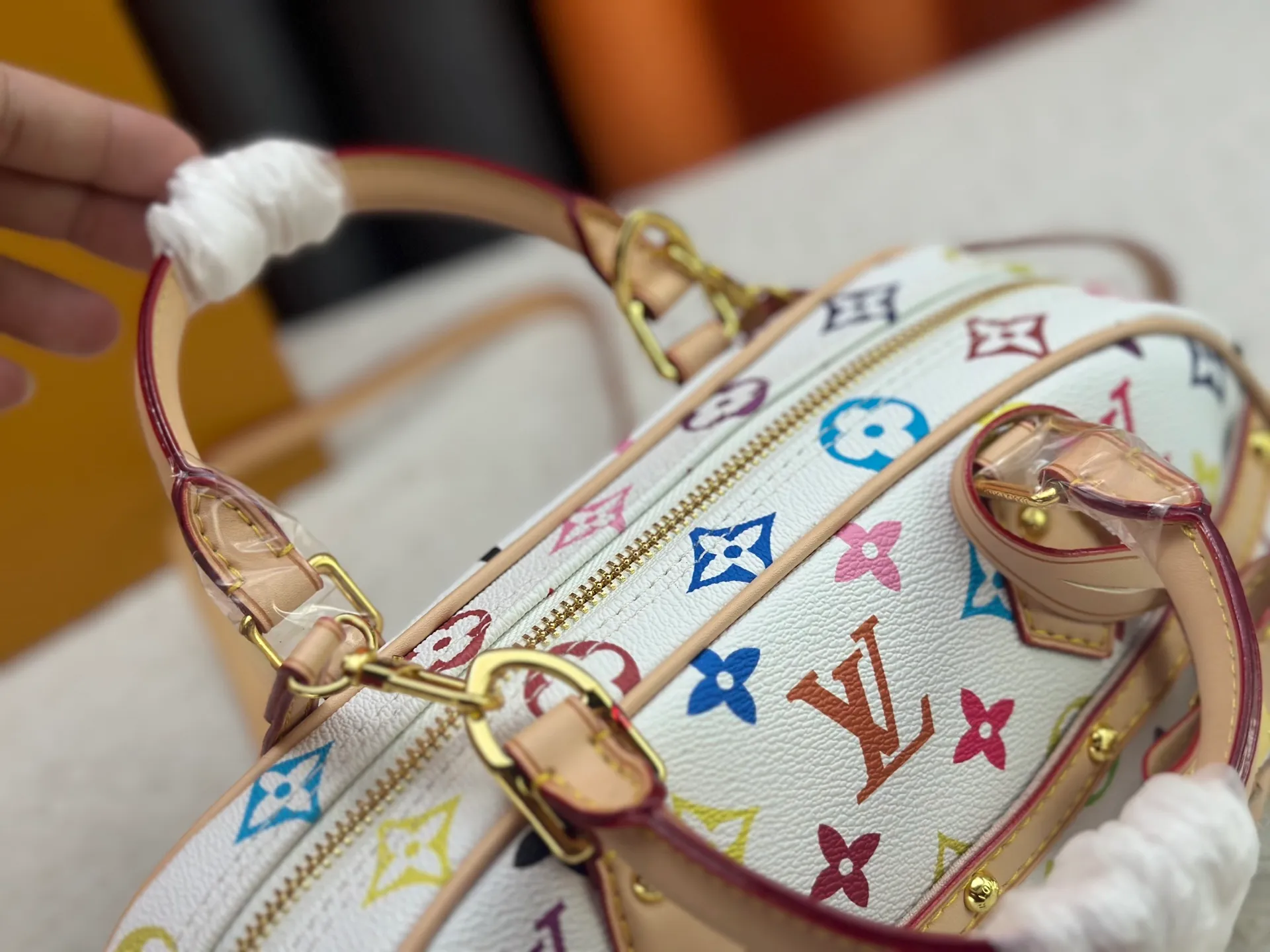 P280 Upgraded Original M13084 This Handbag East West handbag is from the Louis Vuitton x Takashi Murakami reissue series, using the artist's signature rainbow tones to trace the full-length Monogram pattern. Sleek horizontal construction lines the top handle, studded side straps, detachable and adjustable shoulder strap and LV x TM key holder, with cowhide leather details and sophisticated corners that nod to the brand's traditional luggage. Dimensions: 27.0 x 14.0 x 10.0 cm (length x height x width)