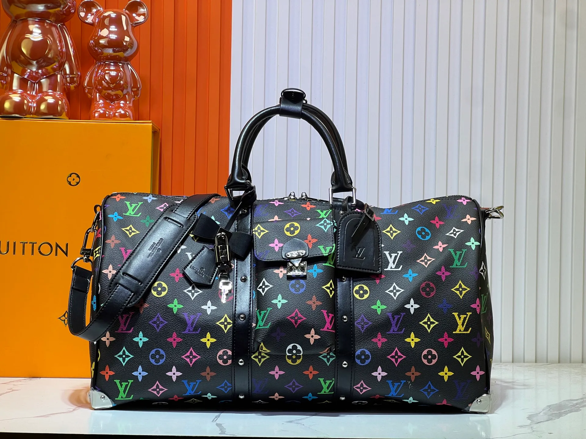 Batch 520💰 M13742 white color black color travel bag new season LV x TM KEEPALL BANDOULIÈRE 45 travel bag This Keepall Bandoulière 45 Jh travel bag is from the Louis Vuitton The S-lock buckle and glossy metal corners on the front pocket establish a classic foundation, while the rivet ribbon and bow-shaped key bag highlight the new season trend. 27 x 20 x 45 cm.