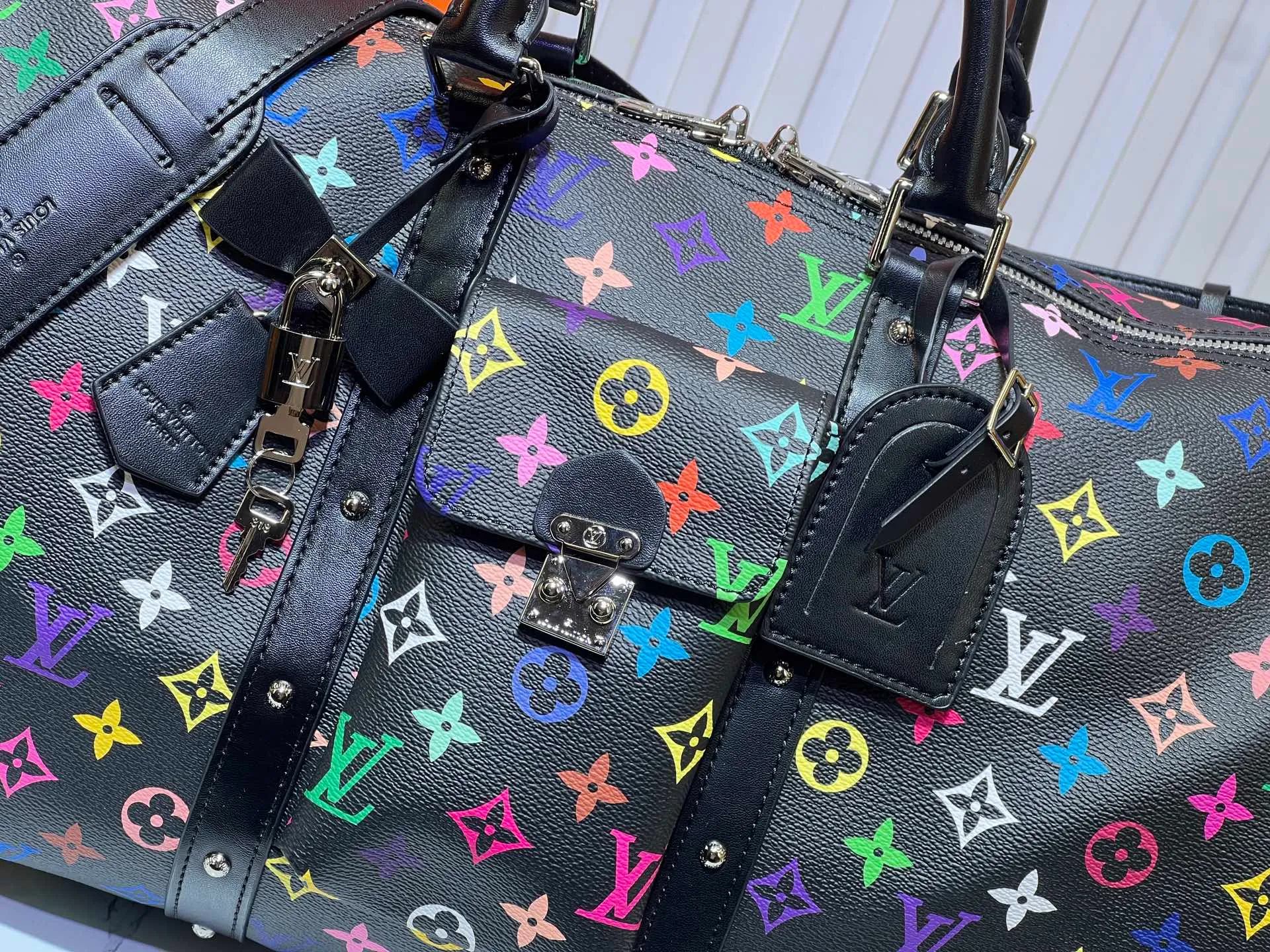 Batch 520💰 M13742 white color black color travel bag new season LV x TM KEEPALL BANDOULIÈRE 45 travel bag This Keepall Bandoulière 45 Jh travel bag is from the Louis Vuitton The S-lock buckle and glossy metal corners on the front pocket establish a classic foundation, while the rivet ribbon and bow-shaped key bag highlight the new season trend. 27 x 20 x 45 cm.