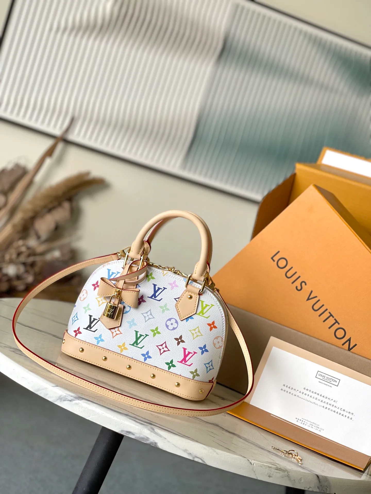 💰1080 Top original order M13078 This AmaBB handbag is filled with the joyful style of the Louis Vuitton x Murakami collaboration series, cleverly recalling the Art Deco style design of the 1930s. Monogram coated canvas is dyed in Murakami’s playful tones, and classic cow leather elements are incorporated into the Toron handle, bag base, detachable shoulder strap and LVxTM key bag. Dimensions: 23.5 × 17.5 × 11.5 cm