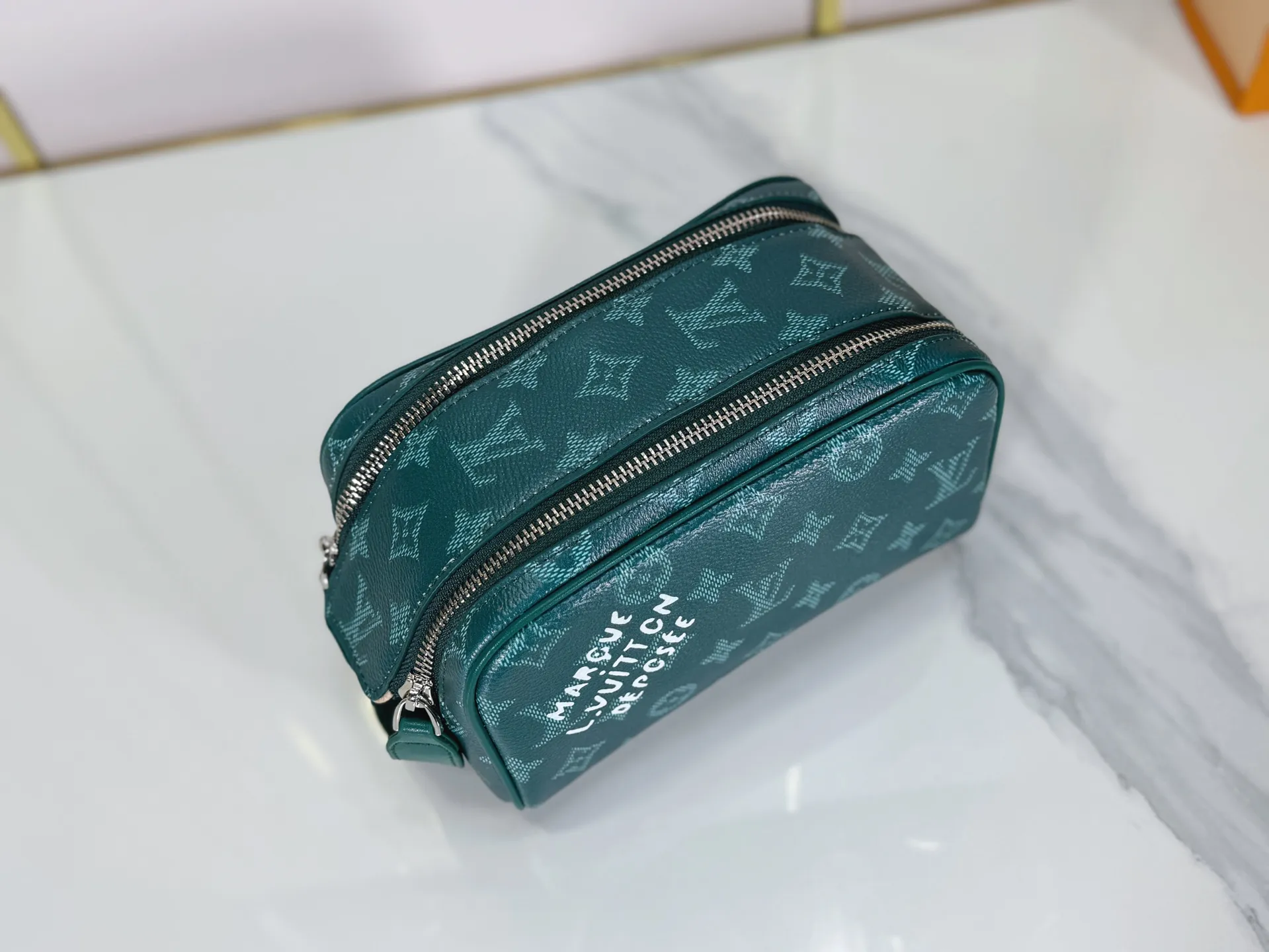 P180 Upgraded original M26872 M27158 M26871 M26870 This Dopp Kit mini toiletry bag is made of brightly colored Monogram Heritage coated canvas with cow leather details. The double-zipper wide-mouth closure makes it easy to access toiletries, and the washable fabric lining adds functionality. Dimensions: 20 x 13 x 12 (cm) ((length x height x width)