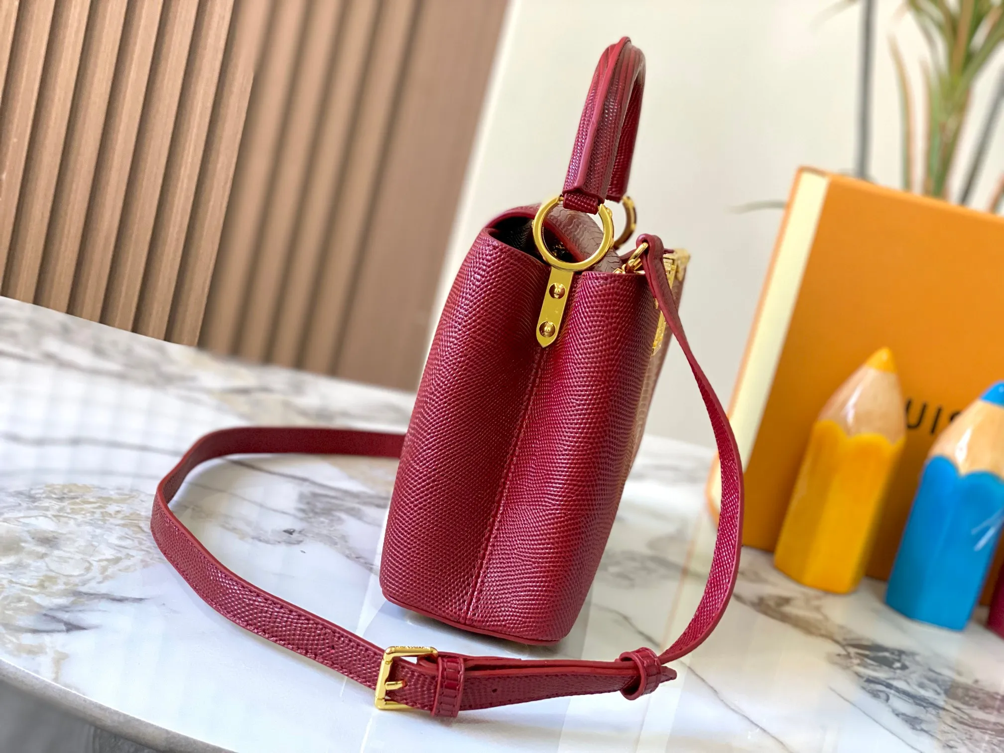 Top original P460 Guangzhou-made M12297 maroon lizard skin with gold and diamond corolla 🔺This CapucinesBB handbag exquisitely combines elegant lizard skin outer layer, delicate sheepskin lining and gleaming metal parts. The iconic flip cover achieves two styles. The LV logo can be read on the inside and the Monogram flower blooms on the outside. It lights up an eye-catching corner for evening occasions and adds a personalized atmosphere to the wardrobe. Shine gorgeous style in day and night occasions.  Detailed features 27 x 18 x 9 cm (length x height x width)