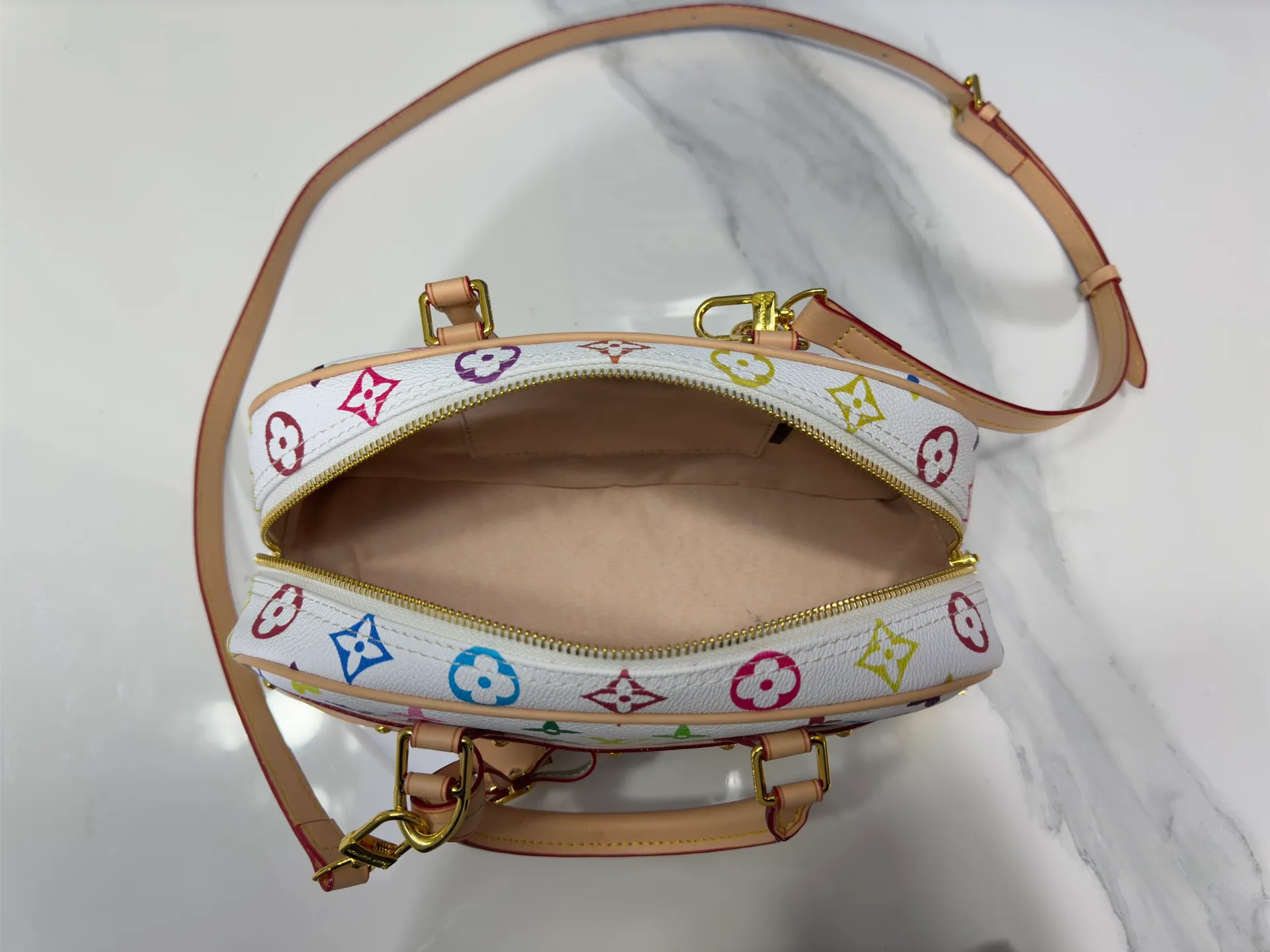 P300 Upgraded Original M13084 This Handbag East West handbag is from the Louis Vuitton x Takashi Murakami reissue series, using the artist's signature rainbow tones to trace the full-length Monogram pattern. Sleek horizontal construction lines the top handle, studded side straps, detachable and adjustable shoulder strap and LV x TM key holder, with cowhide leather details and sophisticated corners that nod to the brand's traditional luggage. Dimensions: 27.0 x 14.0 x 10.0 cm (length x height x width)
