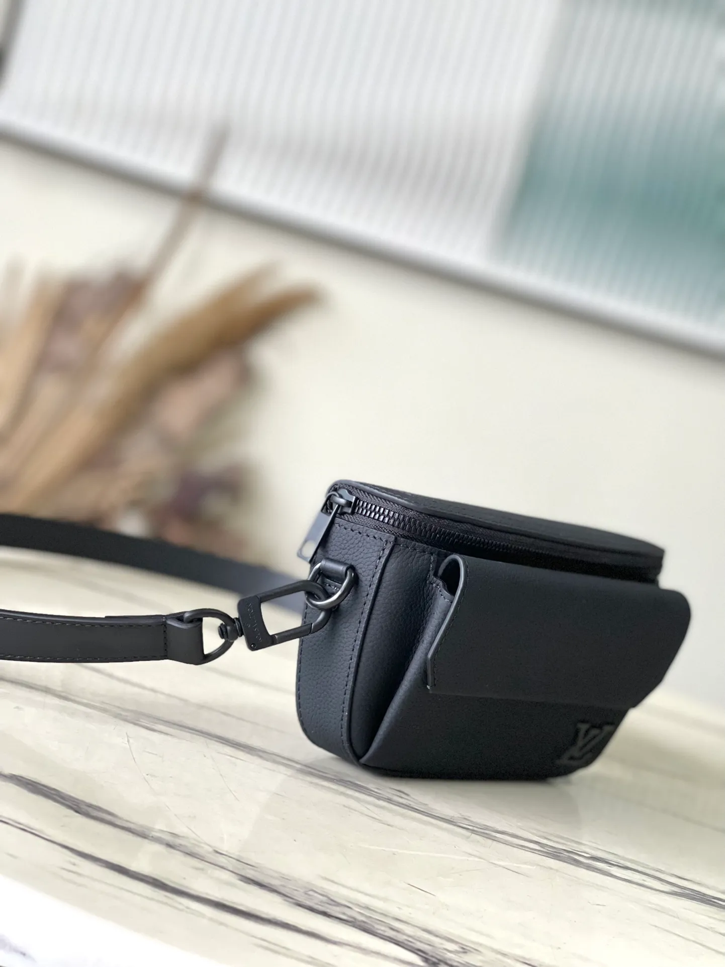 💰940 (top layer leather) top quality original order M83563 black. This Pilot mini handbag is made of grained cow leather with a rounded shape, providing a trendy choice for daily travel. A zippered main compartment ensures secure storage, and a front pocket provides easy access to small items like your phone or keys. Detachable shoulder strap allows for comfortable shoulder or cross-body wear. Dimensions: 20 × 12 × 5,5 cm