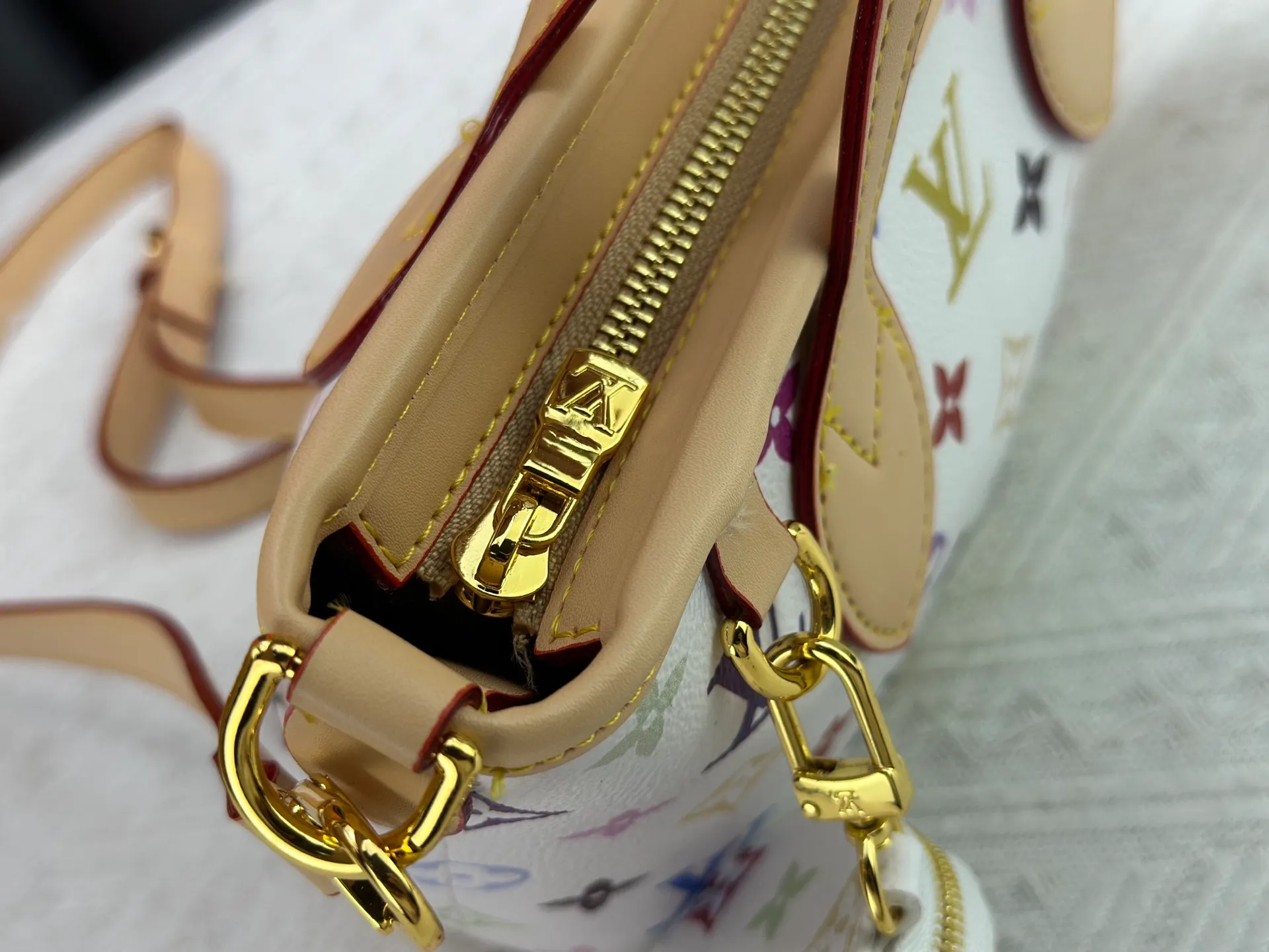 P280 M46705 NEVERFULL BB handbag white tricolor Takashi Murakami co-branded Neverfull classic handbag, explore the exquisite details inside the bag. The redesigned inner bag is equipped with details inspired by the Louis Vuitton archives. The pocket is lined with linen fabric.