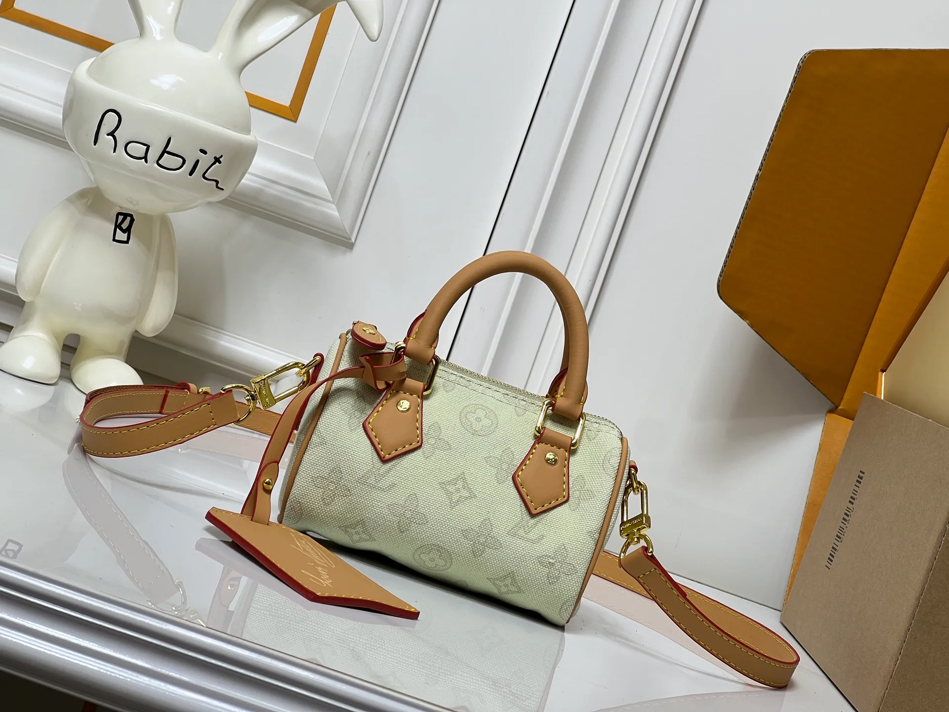 Batch 240💰M28322 Red M28323 M27610 M81085 [Exclusive background shot] This Nano Speedy handbag condenses the configuration of Louis Vuitton's classic Speedy handbag. It is made of Monogram canvas with distressed cow leather details and dazzling metal parts, making it easy to carry with you for daily needs. The handles and removable and adjustable shoulder strap allow for a variety of styling possibilities. 16.0 x 10.0 x 7.5 cm (L x H x W) • Monogram coated canvas • Cow leather trim • Metal hardware • Zipper closure • Space to store daily necessities such as a 6.1-inch smartphone, card holder and lipstick • Shoulder strap: removable, adjustable • Half-length strap: 45.5 cm • Half-length strap adjustable to: 54.0 cm • Handle: Double handle