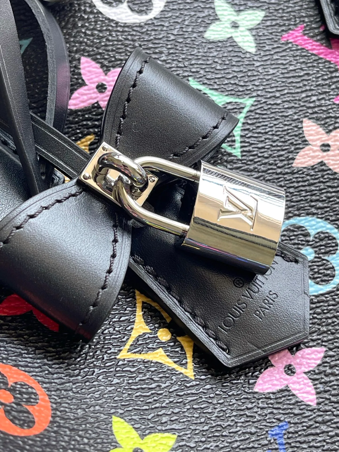 💰1180 Top Original M13257 This SpeedySoft 30 handbag is made of soft coated canvas, and the full-length Monogram pattern is traced in colorful rainbow tones, highlighting the smart style of the x Murakami Takashi reissue series. The Toron handle and detachable shoulder strap are constructed of cow leather, the metal corners recall classic luggage elements, and the bow-shaped key bag and padlock add brand touches. Dimensions: 30 × 21 × 17 cm