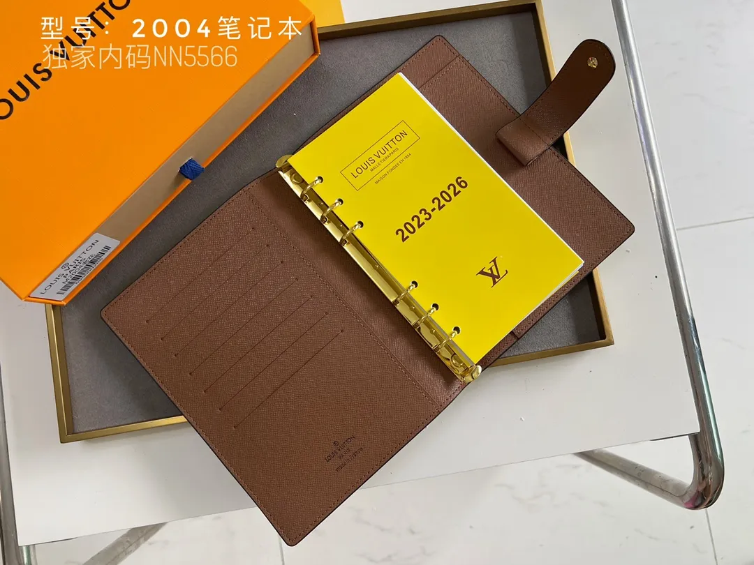 💰140 Top Original 💎 Latest Date 📅 Notepad This small notepad cover is made of Monogram canvas and can hold three credit cards. It can also be used as an address book, notebook or calendar. Epi leather is delicately embossed with LV initials and is lined with intertwined textured leather - Push-button closure - Six-ring binder with three rings in a set, six credit card slots and two internal compartments - Notepad insert available separately. Model: 2004 Size: 14x18cm
