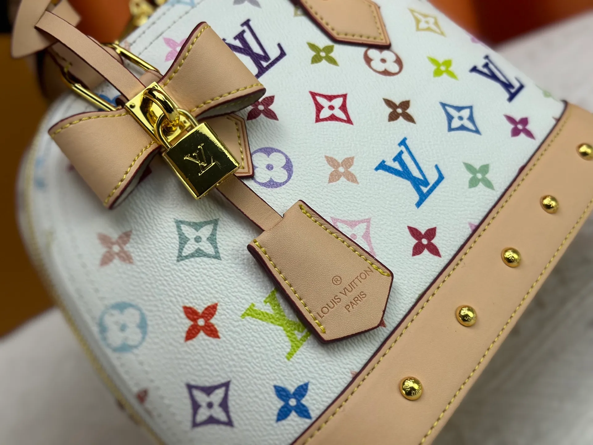 P300 Upgraded original M13078 M53152 This Alma BB handbag exudes the cheerful style of the Louis Vuitton x Murakami collaboration series, cleverly recalling the Art Deco design of the 1930s. Monogram coated canvas renders Murakami's playful tones, while classic calfskin touches the Toron handle, base, detachable shoulder strap and LV x TM key holder. 17.5 x 11.5 x 23.5 cm (height x width x length)