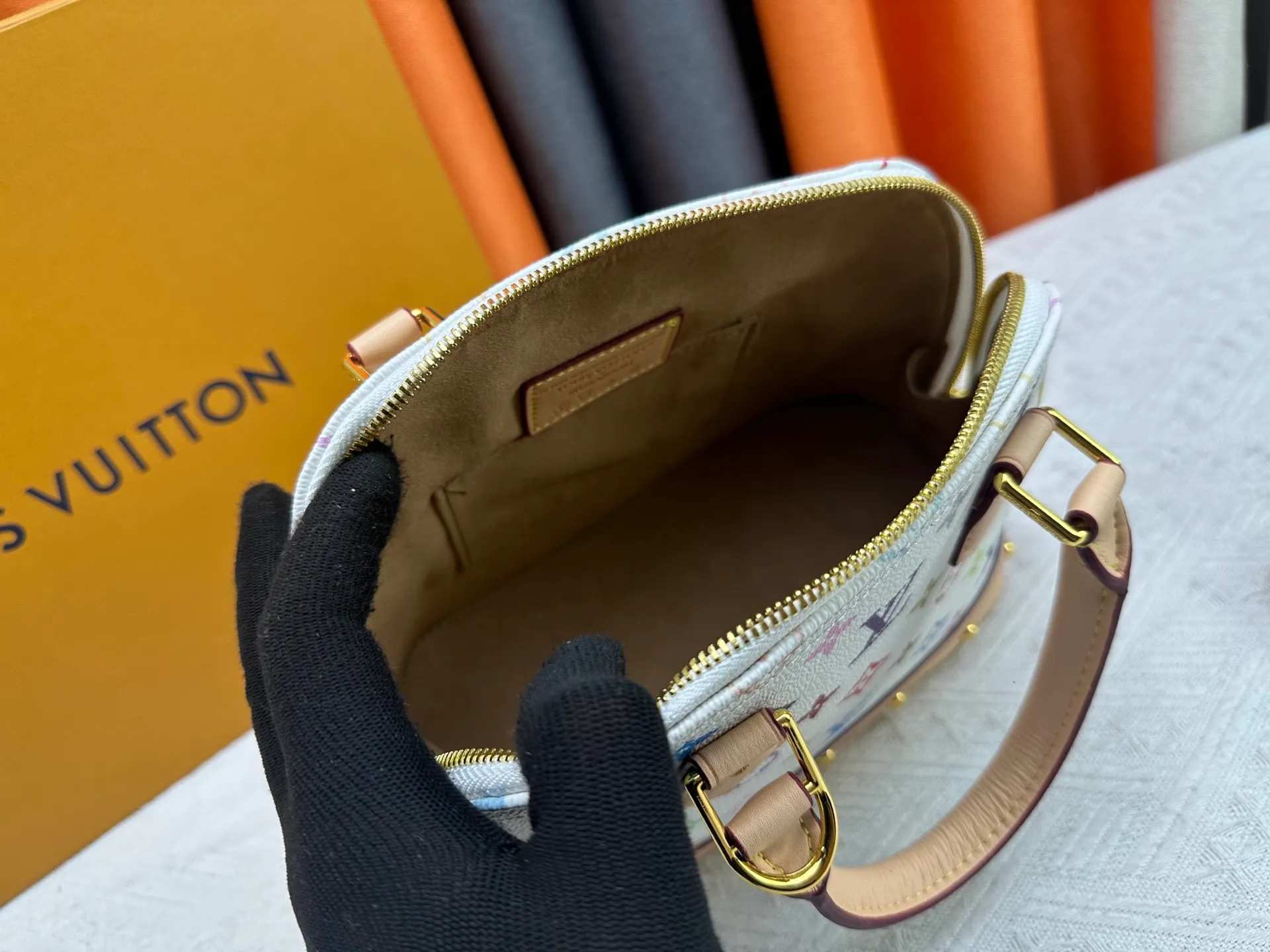 P300 Upgraded original M13078 M53152 This Alma BB handbag exudes the cheerful style of the Louis Vuitton x Murakami collaboration series, cleverly recalling the Art Deco design of the 1930s. Monogram coated canvas renders Murakami's playful tones, while classic calfskin touches the Toron handle, base, detachable shoulder strap and LV x TM key holder. 17.5 x 11.5 x 23.5 cm (height x width x length)