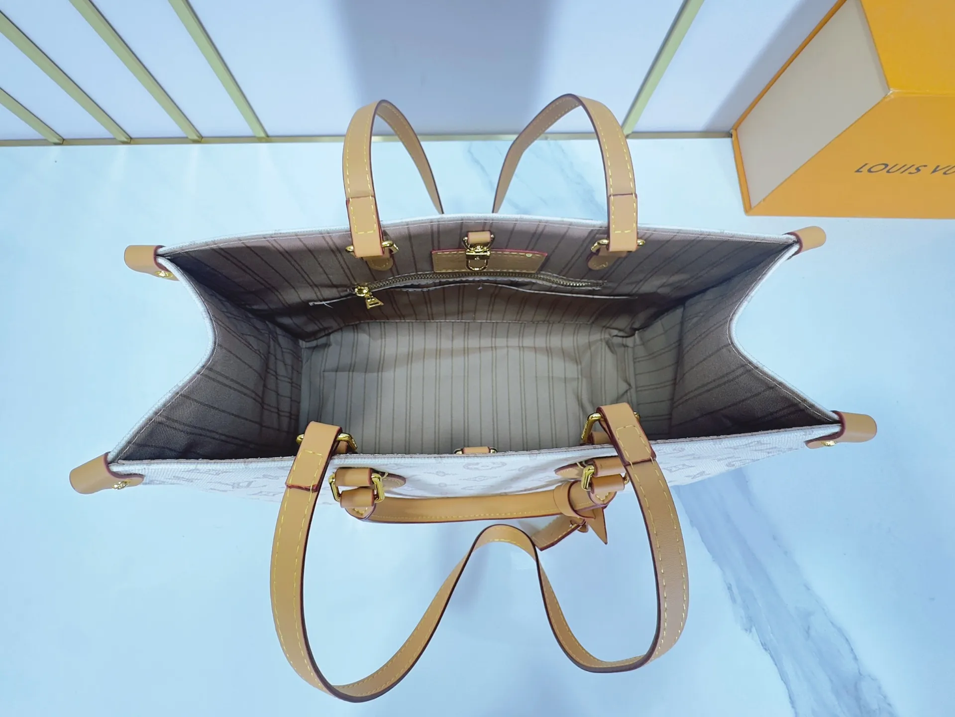 P260 Upgraded original M28289 M45495 M44571 To celebrate the 130th anniversary of the Louis Vuitton Monogram pattern, this OnTheGo medium handbag chooses Monogram Origine Bleu Courrier pattern canvas to reinterpret the classic elements from a retro perspective. The shoulder straps, handles and address plaque are cut out of cowhide, and the striped lining and pockets open to reveal. Zipper bag securely stores valuables. Dimensions: 35 x 27 x 14 (cm) ((length x height x width)