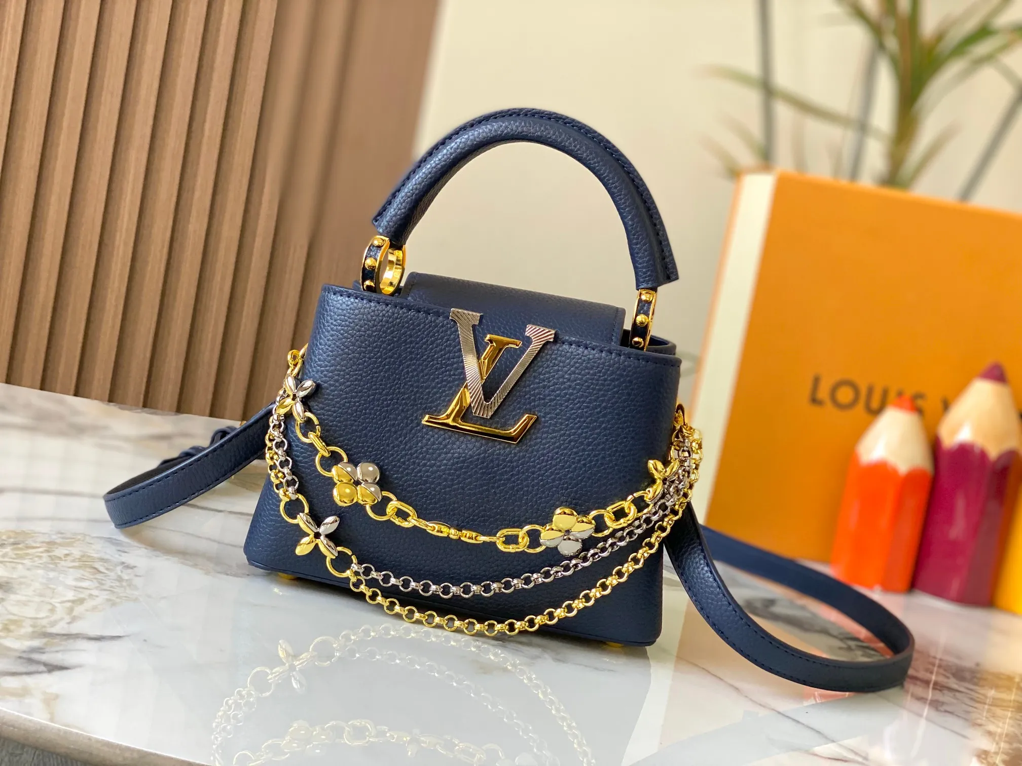 P480 [Guangzhou top quality original version] M26351 Blue This modern version of the Capucines mini is made of timeless Taurillon leather and equipped with a jewelry-inspired Infinity chain. The bag is decorated with double galvanized metal parts, including the iconic Monogram floral pattern, and the LV Initials logo created with sunburst technology, creating a sundial-like light and shadow effect. The bag has multiple pockets and a detachable shoulder strap, allowing it to be carried on one shoulder or across the body. 14 x 8 x 21 cm (height x width x length)