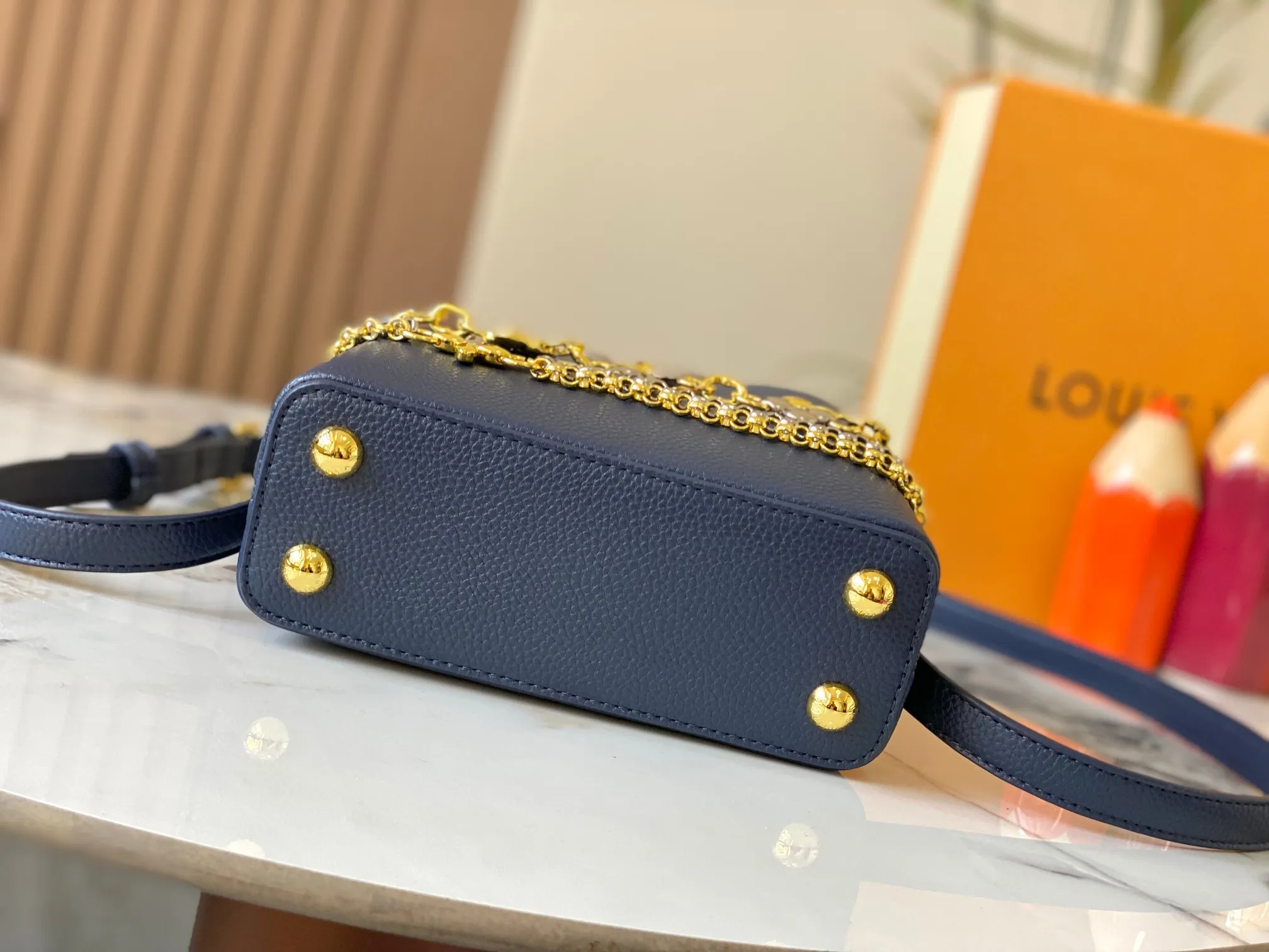 P480 [Guangzhou top quality original version] M26351 Blue This modern version of the Capucines mini is made of timeless Taurillon leather and equipped with a jewelry-inspired Infinity chain. The bag is decorated with double galvanized metal parts, including the iconic Monogram floral pattern, and the LV Initials logo created with sunburst technology, creating a sundial-like light and shadow effect. The bag has multiple pockets and a detachable shoulder strap, allowing it to be carried on one shoulder or across the body. 14 x 8 x 21 cm (height x width x length)