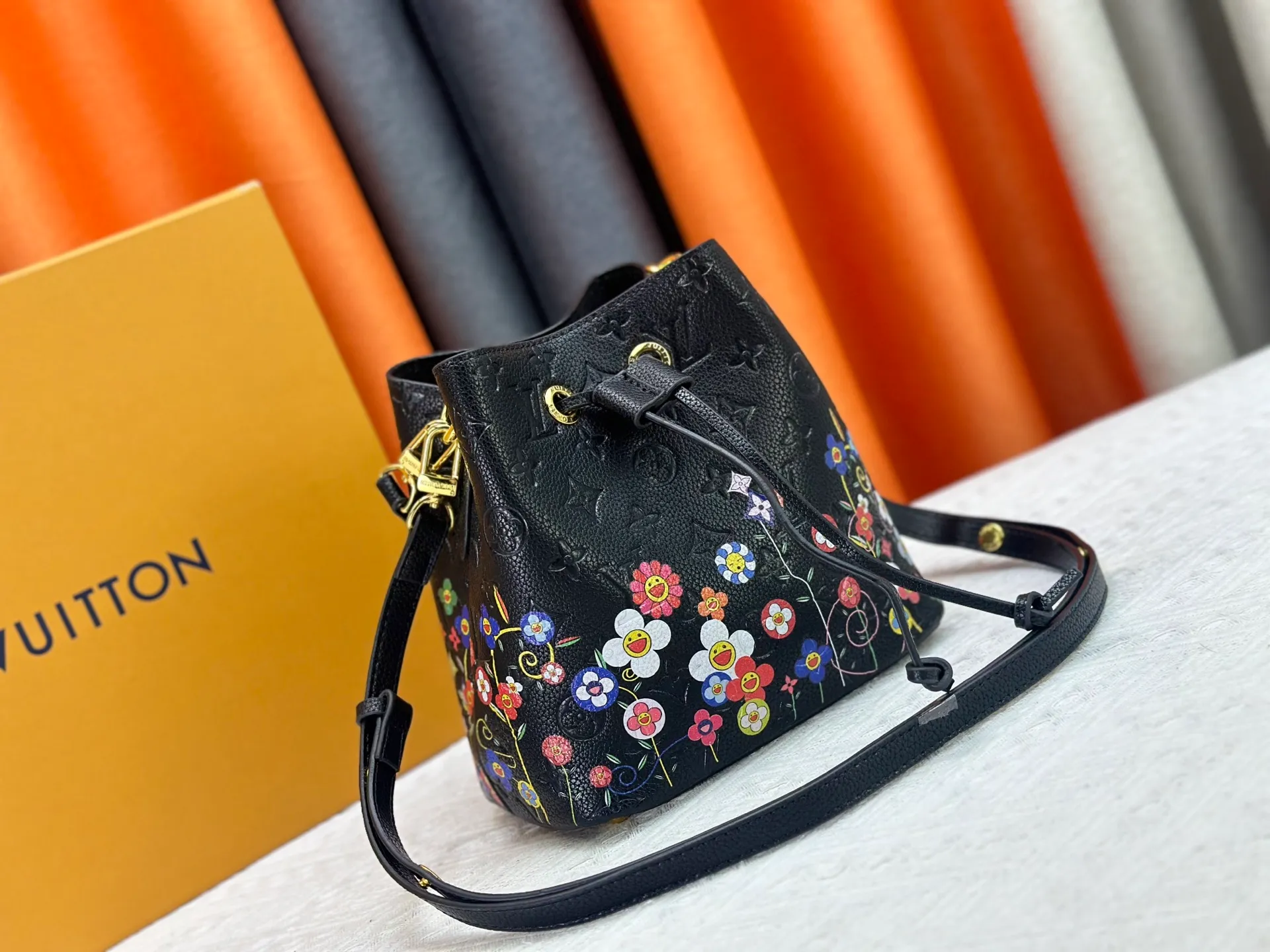 P240 M13676 M44021 This NeoNoe BB bucket bag comes from the Louis Vuitton × Murakami replica series, using Monogram Empreinte leather to convey a fresh breath and smart style. Murakami's signature Cherry Blossom pattern appears on the Monogram embossed surface, and the same floral element is transformed into a slide buckle to tighten the drawstring. Size: 20x20x13cm