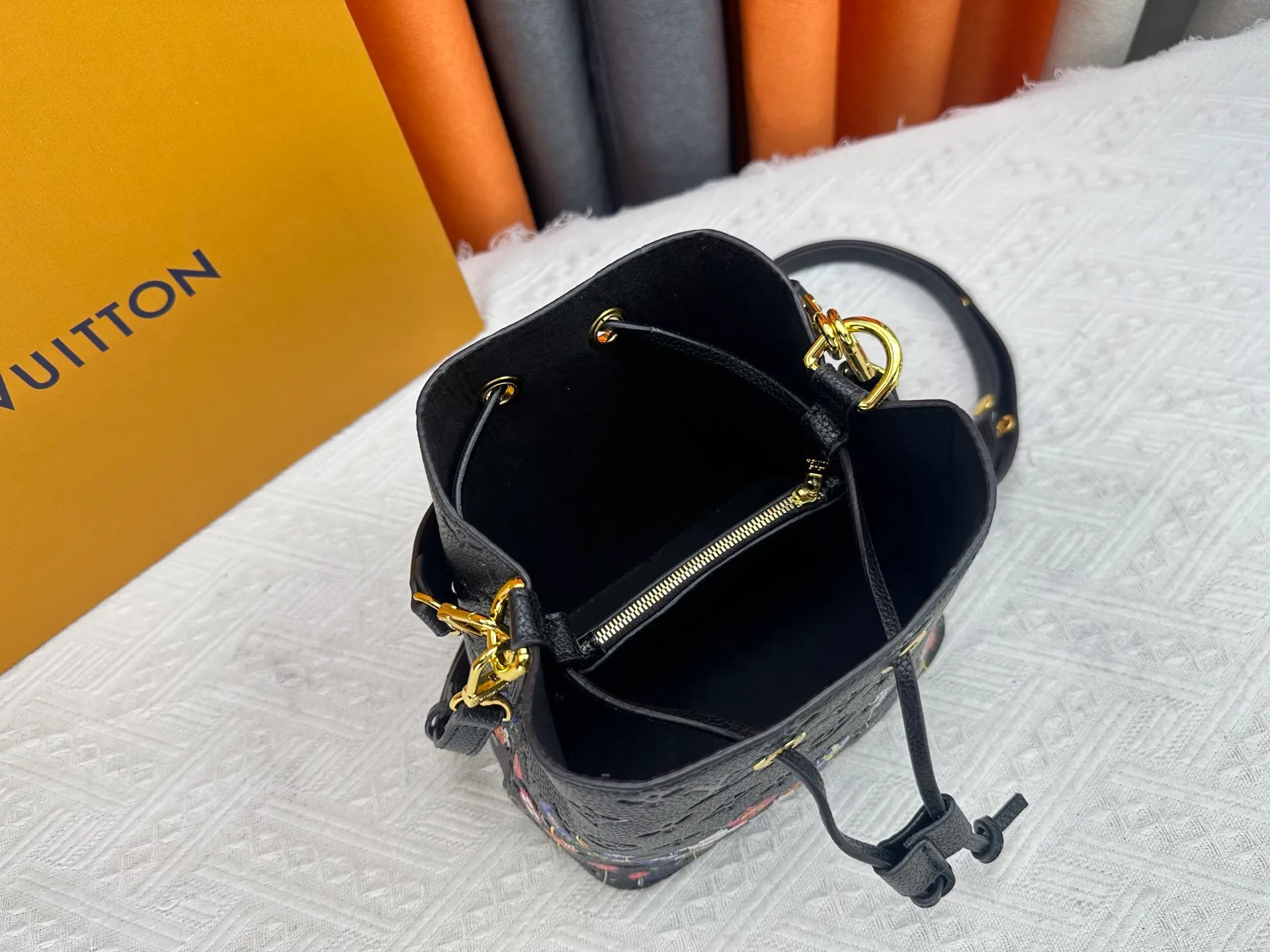 P240 M13676 M44021 This NeoNoe BB bucket bag comes from the Louis Vuitton × Murakami replica series, using Monogram Empreinte leather to convey a fresh breath and smart style. Murakami's signature Cherry Blossom pattern appears on the Monogram embossed surface, and the same floral element is transformed into a slide buckle to tighten the drawstring. Size: 20x20x13cm