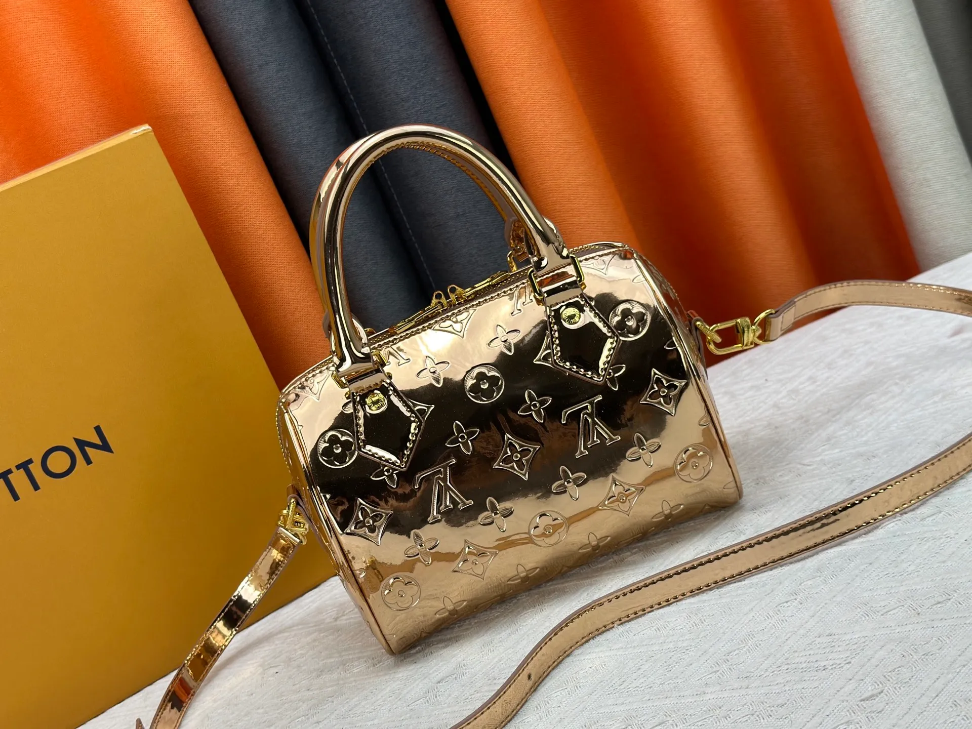 P260 M11987 M58953 Rose Gold This Speedy Bandoulière 20 handbag is from the LV Ski series. It is made of embossed coated canvas with smooth leather trimming and bright metal parts, and uses the new Monogram Miroir effect to express the retro-futuristic concept. The detachable and adjustable leather shoulder strap allows for a variety of carrying options, and the compact design can accommodate daily needs such as a long wallet. Dimensions: 20.5x13.5x12