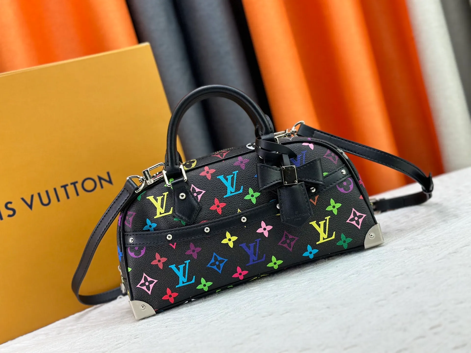 P280 Upgraded Original M13084 This Handbag East West handbag is from the Louis Vuitton x Takashi Murakami reissue series, using the artist's signature rainbow tones to trace the full-length Monogram pattern. Sleek horizontal construction lines the top handle, studded side straps, detachable and adjustable shoulder strap and LV x TM key holder, with cowhide leather details and sophisticated corners that nod to the brand's traditional luggage. Dimensions: 27.0 x 14.0 x 10.0 cm (length x height x width)
