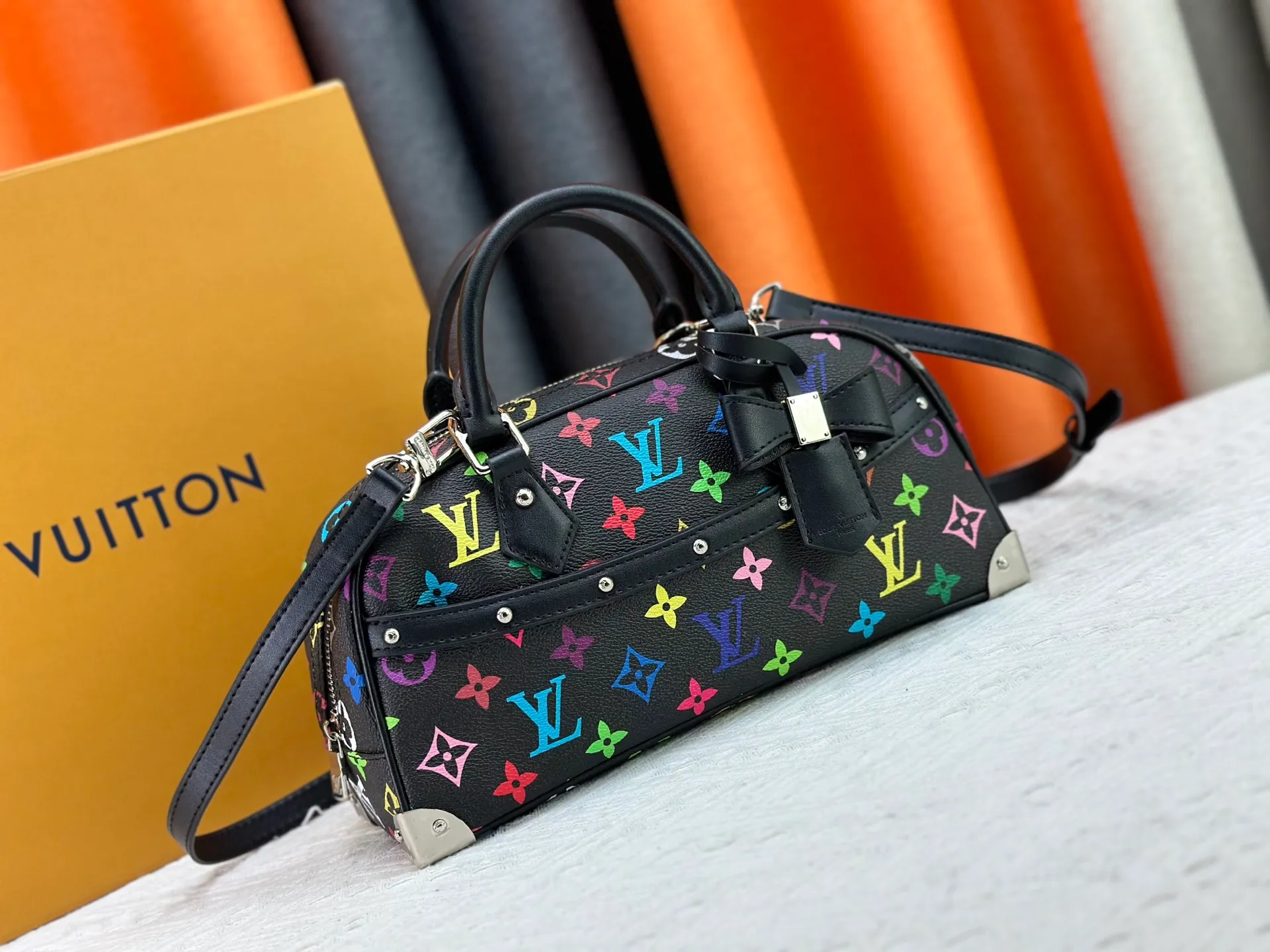 P280 Upgraded Original M13084 This Handbag East West handbag is from the Louis Vuitton x Takashi Murakami reissue series, using the artist's signature rainbow tones to trace the full-length Monogram pattern. Sleek horizontal construction lines the top handle, studded side straps, detachable and adjustable shoulder strap and LV x TM key holder, with cowhide leather details and sophisticated corners that nod to the brand's traditional luggage. Dimensions: 27.0 x 14.0 x 10.0 cm (length x height x width)