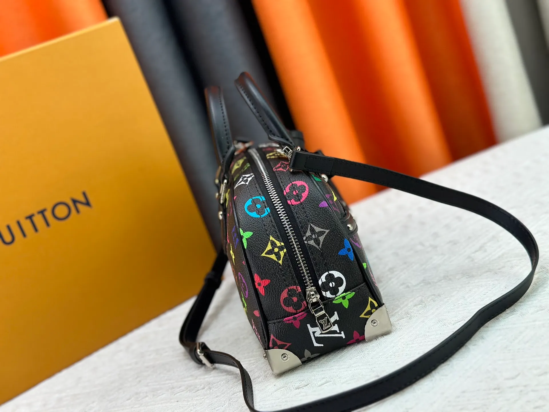 P280 Upgraded Original M13084 This Handbag East West handbag is from the Louis Vuitton x Takashi Murakami reissue series, using the artist's signature rainbow tones to trace the full-length Monogram pattern. Sleek horizontal construction lines the top handle, studded side straps, detachable and adjustable shoulder strap and LV x TM key holder, with cowhide leather details and sophisticated corners that nod to the brand's traditional luggage. Dimensions: 27.0 x 14.0 x 10.0 cm (length x height x width)