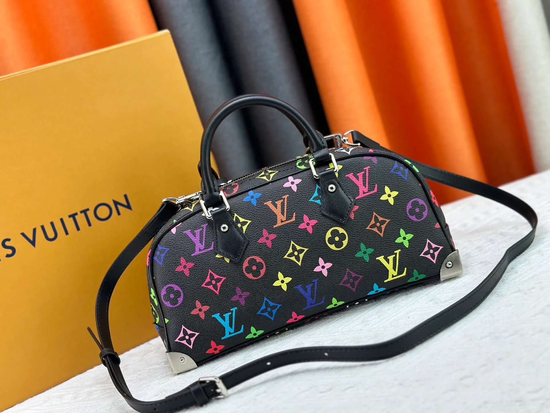 P280 Upgraded Original M13084 This Handbag East West handbag is from the Louis Vuitton x Takashi Murakami reissue series, using the artist's signature rainbow tones to trace the full-length Monogram pattern. Sleek horizontal construction lines the top handle, studded side straps, detachable and adjustable shoulder strap and LV x TM key holder, with cowhide leather details and sophisticated corners that nod to the brand's traditional luggage. Dimensions: 27.0 x 14.0 x 10.0 cm (length x height x width)