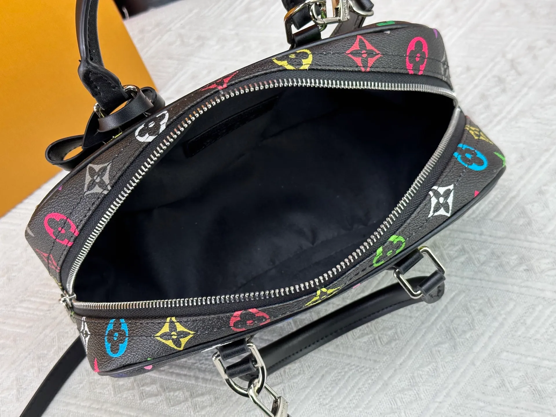 P280 Upgraded Original M13084 This Handbag East West handbag is from the Louis Vuitton x Takashi Murakami reissue series, using the artist's signature rainbow tones to trace the full-length Monogram pattern. Sleek horizontal construction lines the top handle, studded side straps, detachable and adjustable shoulder strap and LV x TM key holder, with cowhide leather details and sophisticated corners that nod to the brand's traditional luggage. Dimensions: 27.0 x 14.0 x 10.0 cm (length x height x width)