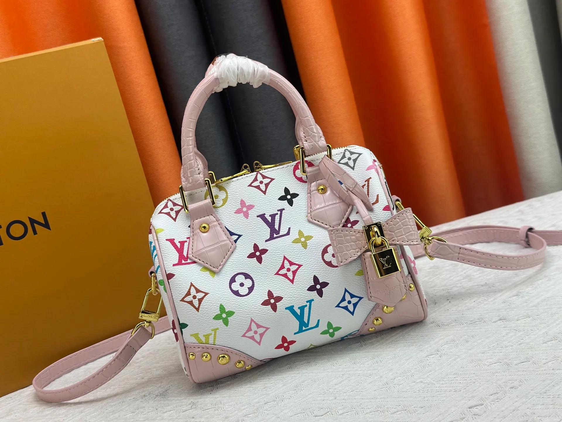P260 Upgraded original crocodile pattern M13365 M58953 M46234 M46222 Speedy Bandoulière 20 handbag is made of soft coated canvas, and the full-length Monogram pattern is traced in colorful rainbow tones, highlighting the smart style of the Louis Vuitton x Murakami reissue series. The Toron handle and detachable shoulder strap are constructed of cow leather, the metal corners recall classic luggage elements, and the bow-shaped key bag and padlock add brand touches. Dimensions: 20.5 x 13.5 x 12.0 cm (length x height x width)