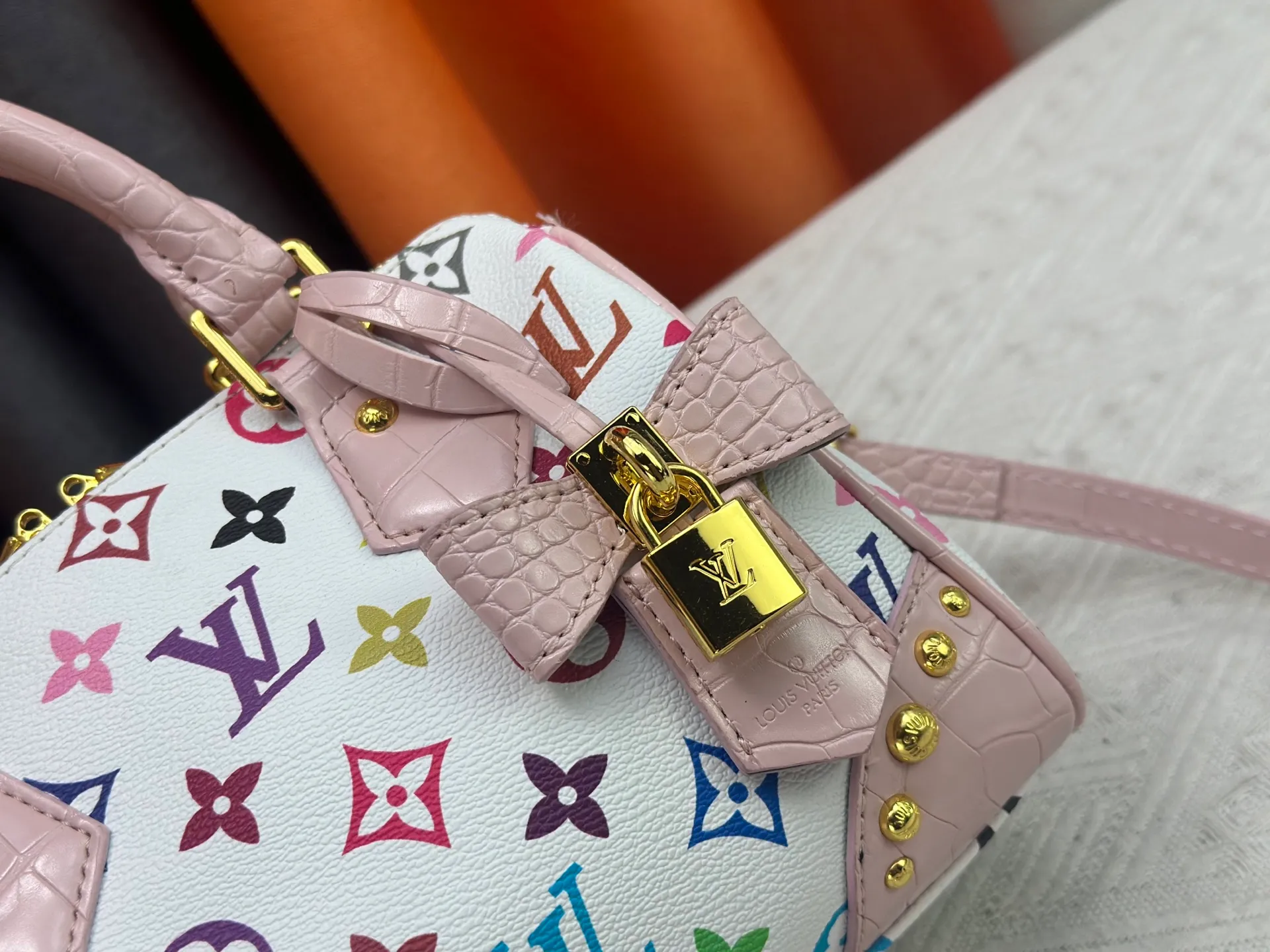P260 Upgraded original crocodile pattern M13365 M58953 M46234 M46222 Speedy Bandoulière 20 handbag is made of soft coated canvas, and the full-length Monogram pattern is traced in colorful rainbow tones, highlighting the smart style of the Louis Vuitton x Murakami reissue series. The Toron handle and detachable shoulder strap are constructed of cow leather, the metal corners recall classic luggage elements, and the bow-shaped key bag and padlock add brand touches. Dimensions: 20.5 x 13.5 x 12.0 cm (length x height x width)
