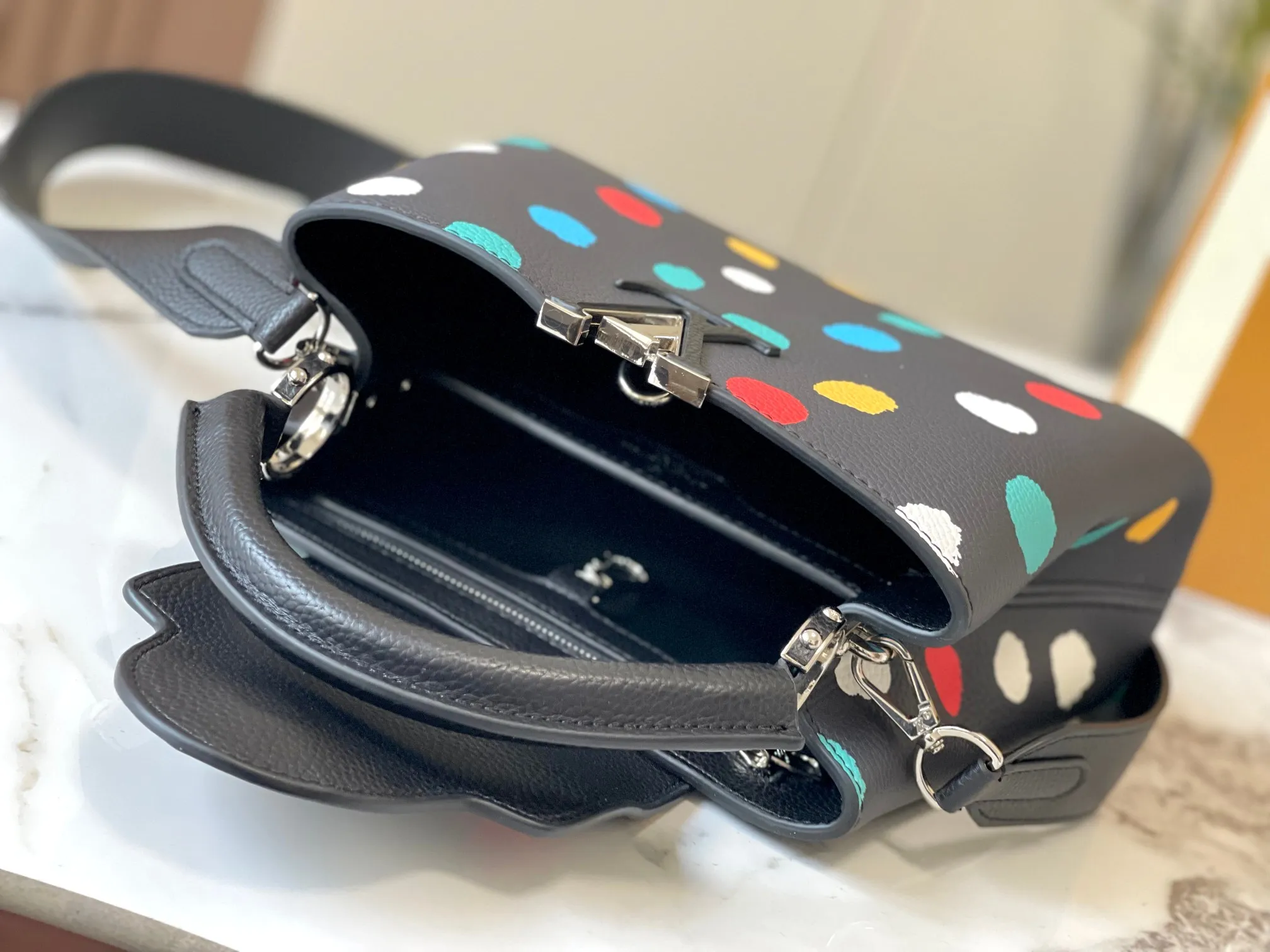Upgraded version P440 M21663 This LV x YK Capucines small handbag comes from the Louis Vuitton x Yayoi Kusama collaboration series. The renowned Japanese artist has been obsessed with polka dots as a symbol of infinity since childhood, and finds a dazzling expression in supple Taurillon leather decorated with 3D hand-painted polka dot prints. Detailed features 27 x 18 x 9 cm (length x height x width)