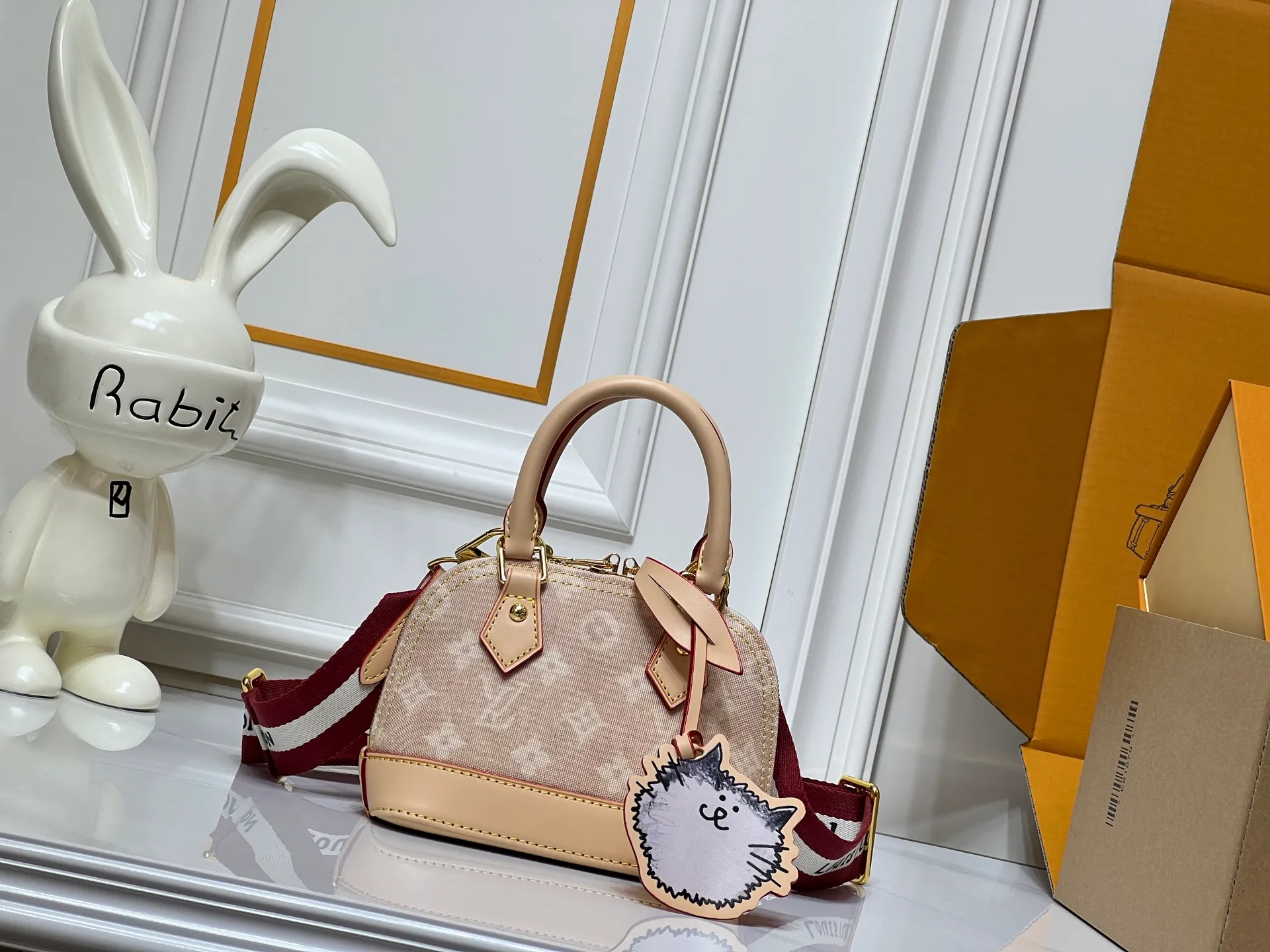 Batch 280💰Alma BB handbag M99021 M82348 M82717 A creative work of Louis Vuitton's Catogram series, the Alma BB handbag is made of light beige denim material and is engraved with the brand's iconic Monogram pattern, showing a retro style. Paired with beige leather trim and gold hardware, the classic shell bag shape incorporates cute cat charms, injecting vitality into the overall look. Equipped with a detachable shoulder strap, it can be carried by hand or cross-body to meet a variety of dressing needs. From daily outings to casual luxury socializing, it combines retro texture and cute design to become an eye-catching item that shows personality and taste. It is a fashionable choice for those who love cute style and classic design. Size: 18x12x8cm