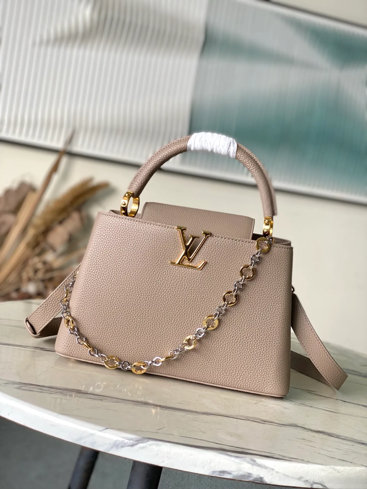 💰2480 "Special Grade Original Leather" M12935 Elephant Gray Medium This Capucines medium handbag is from the Chain On You series. It uses Taurillon cow leather to focus on the brand's ingenuity and sophisticated craftsmanship. The jewelry-style double-plated chain is embellished with Monogram flowers, and the rounded LV letters and metal parts add elegant touches. Whether worn cross-body, hand-carried or shoulder-carried, it can display elegant style. Dimensions: 31.5 × 20 × 11 cm