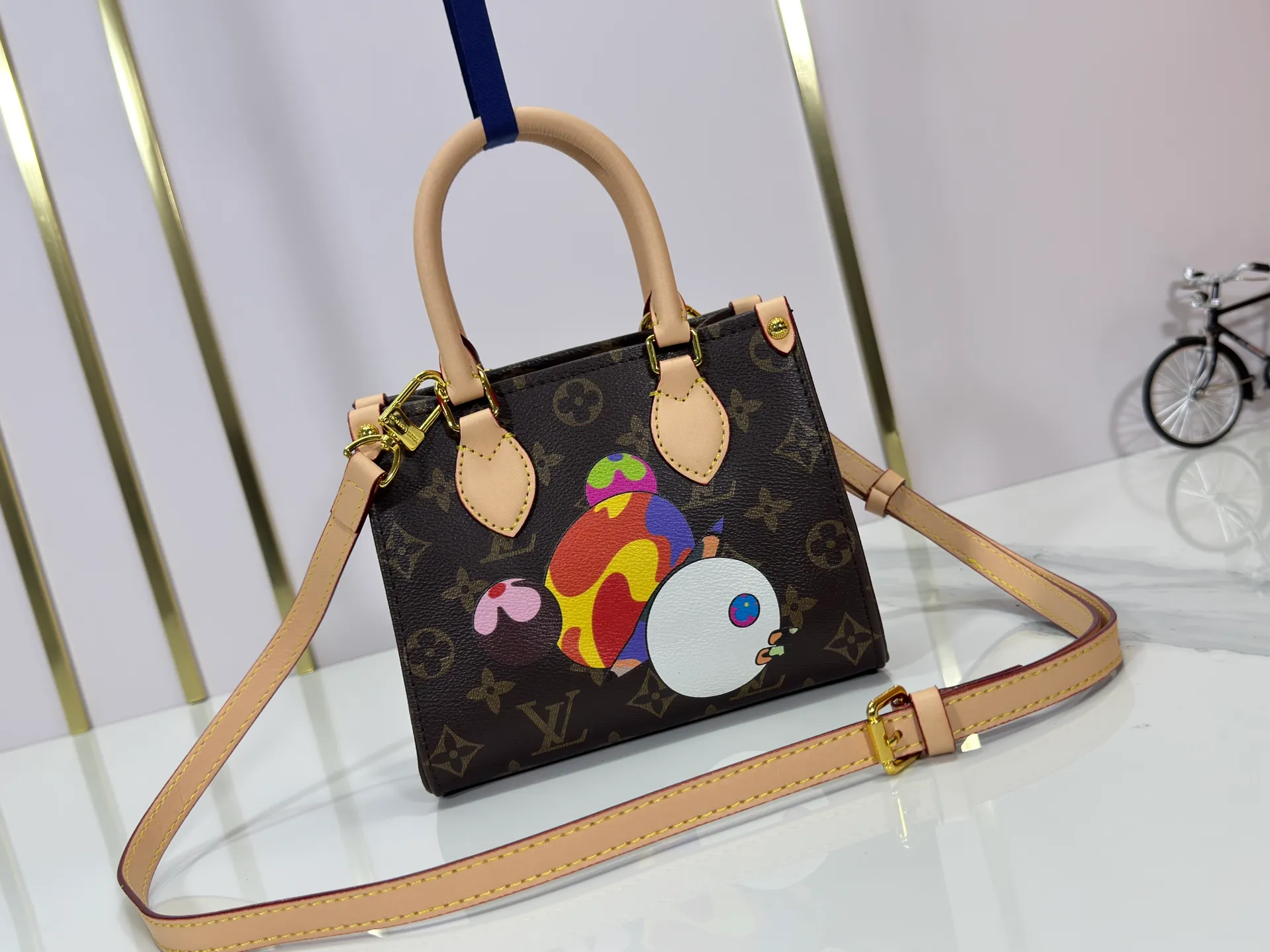 P220 upgraded original M13668 M46839 Louis Vuitton x Murakami reissue series interprets the exquisite version of the OnTheGo handbag with playful touches. Monogram canvas and cow leather establish the brand's classic style, and Murakami's cute and cute panda image is transformed into front and back prints. The detachable and adjustable shoulder strap provides a variety of carrying options, and the zippered interior pocket keeps personal items safe and secure. Dimensions: 18.0 x 15.0 x 8.5 cm (length x height x width)